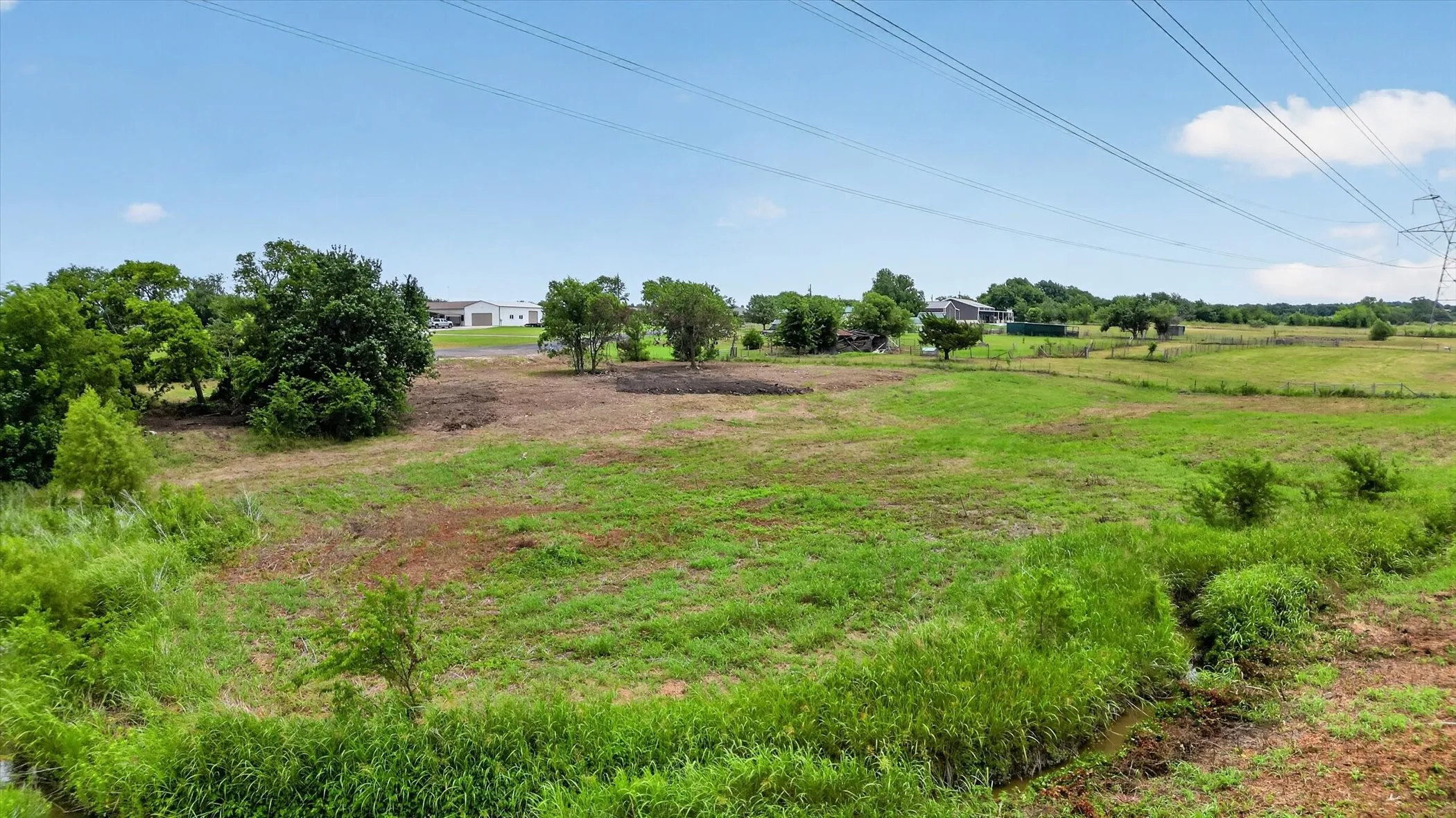 Expansive open land featuring a combination of grassy areas and cleared sections, offering diverse terrain