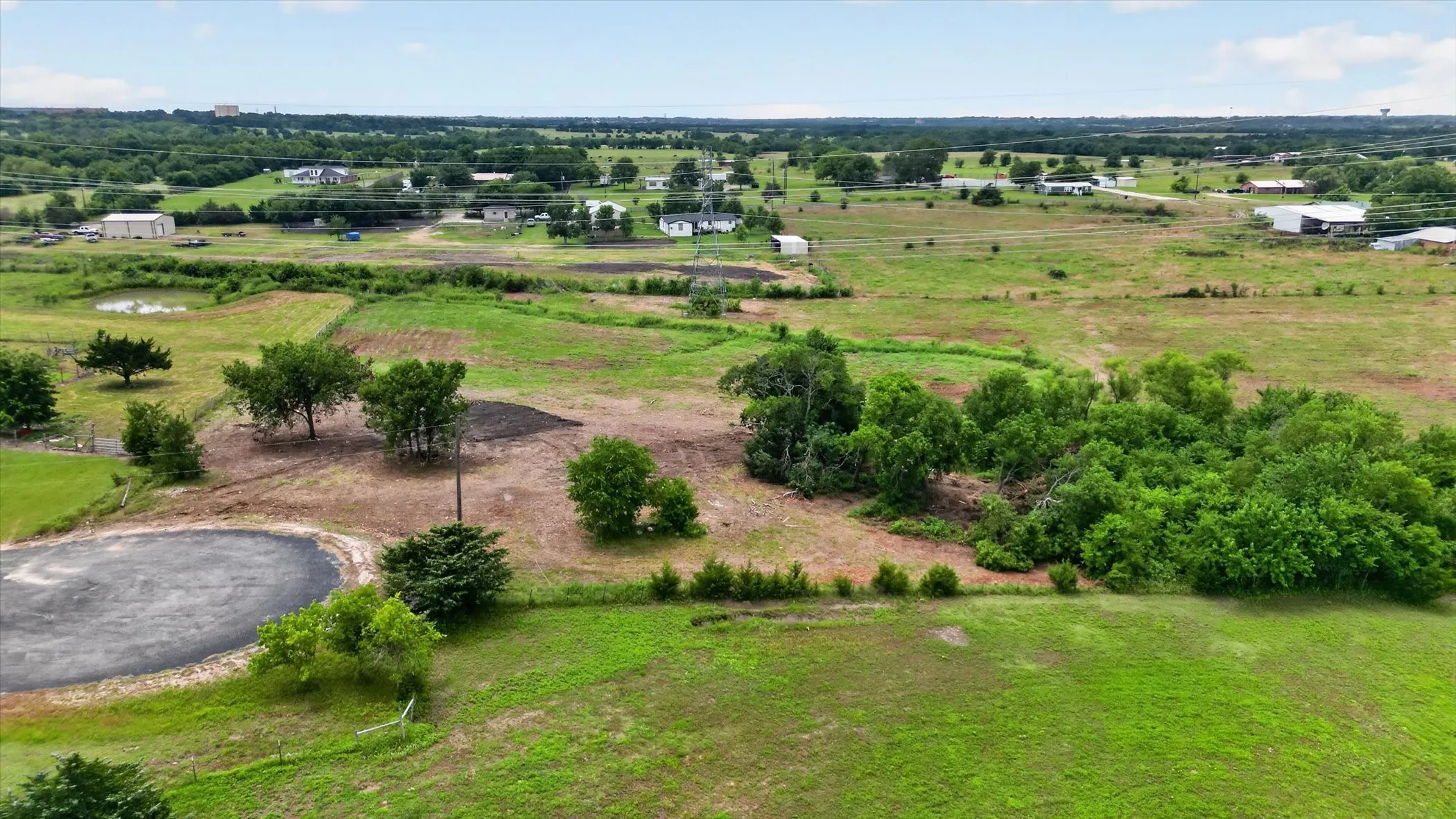 Expansive acreage featuring a mix of cleared land and wooded areas, mature trees, and a pond