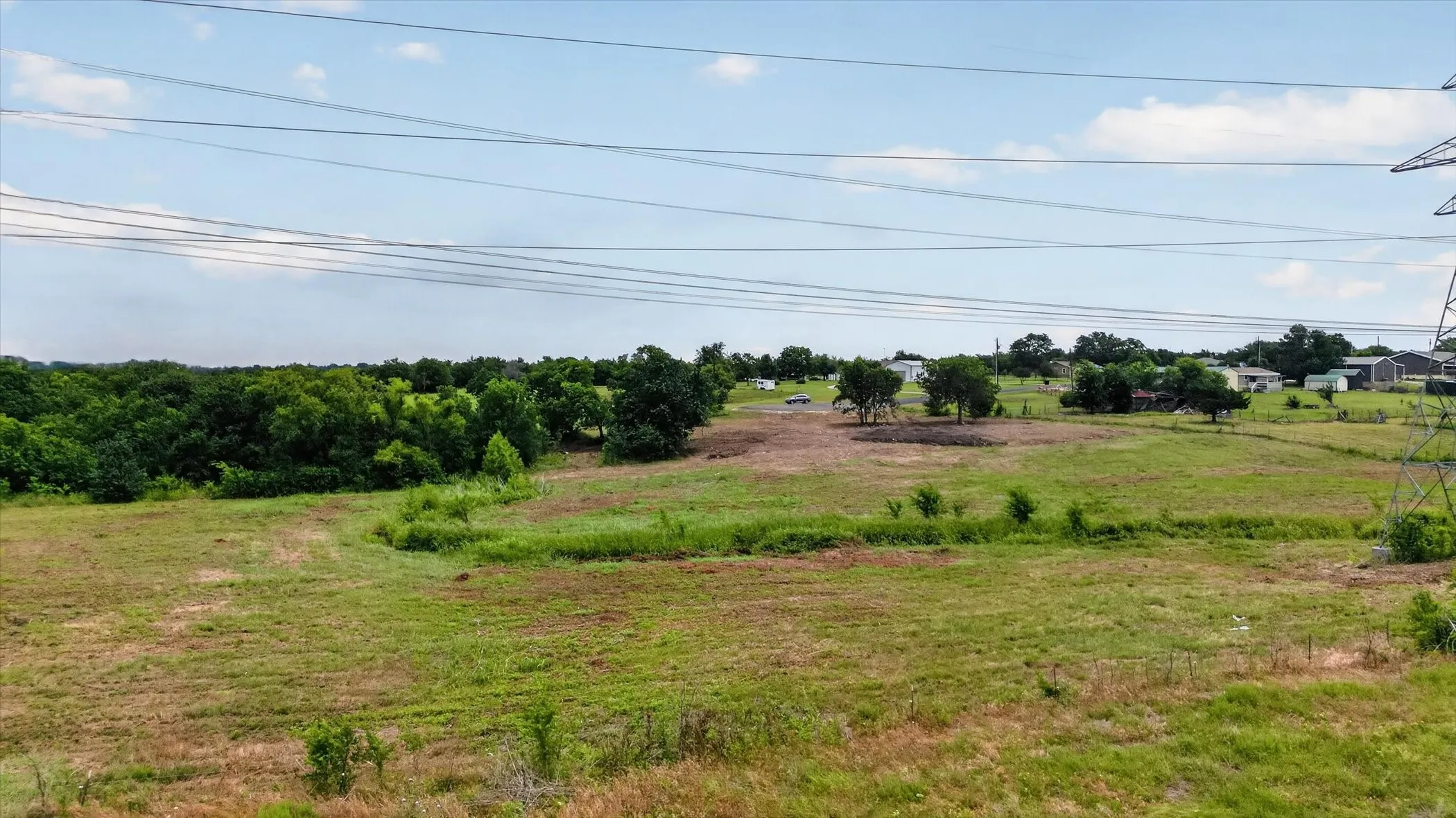 Expansive open land featuring a combination of grassy areas and cleared sections, offering diverse terrain