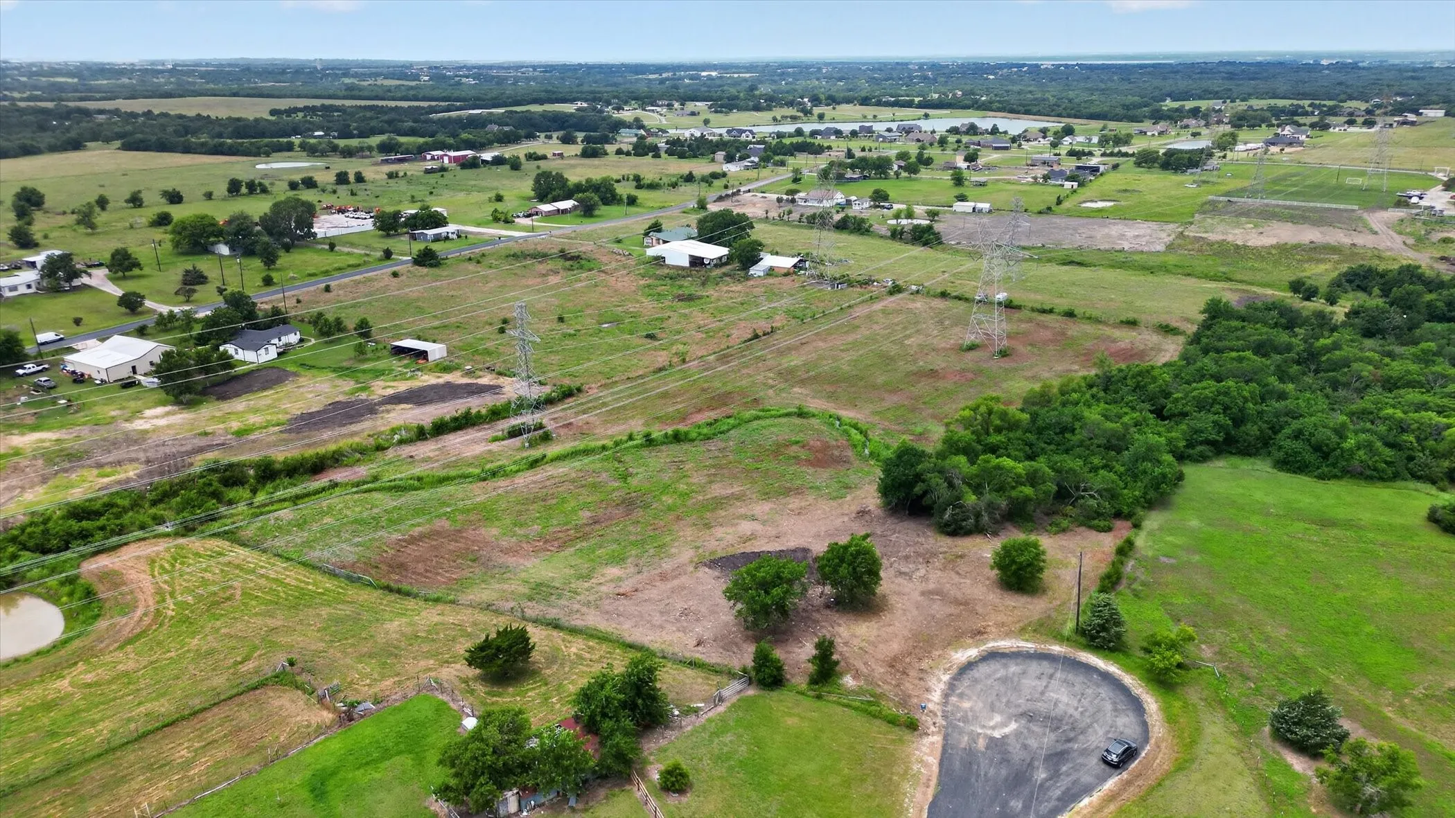 Expansive rural landscape featuring a mix of open fields and mature tree lines