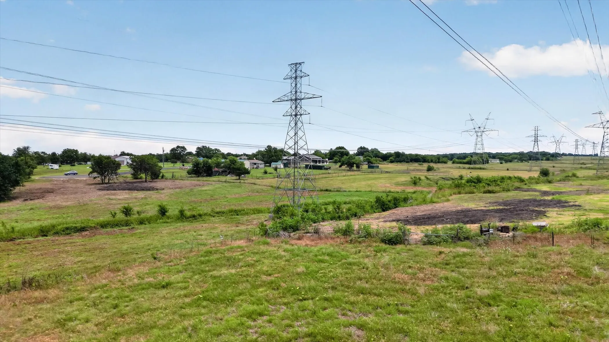Expansive open land featuring a combination of grassy areas and cleared sections, offering diverse terrain