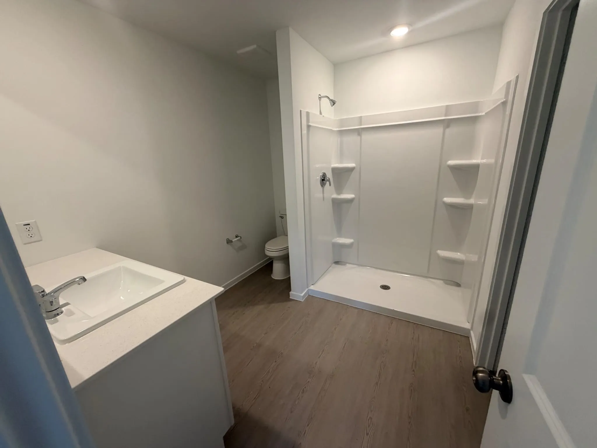Full bathroom with a walk-in shower featuring built-in shelving