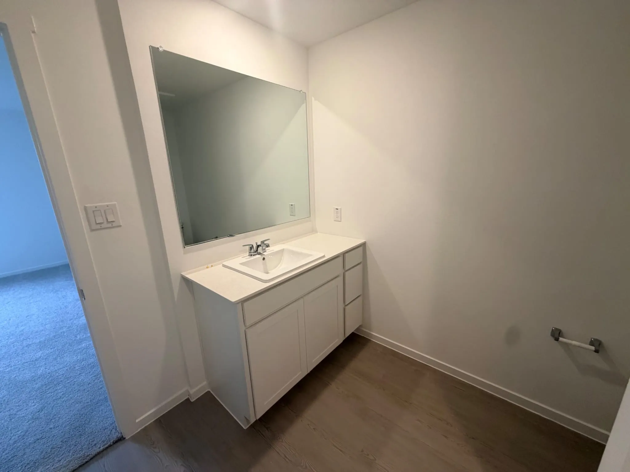 Bathroom vanity with a rectangular undermount sink, a chrome faucet, and a quartz-finish countertop
