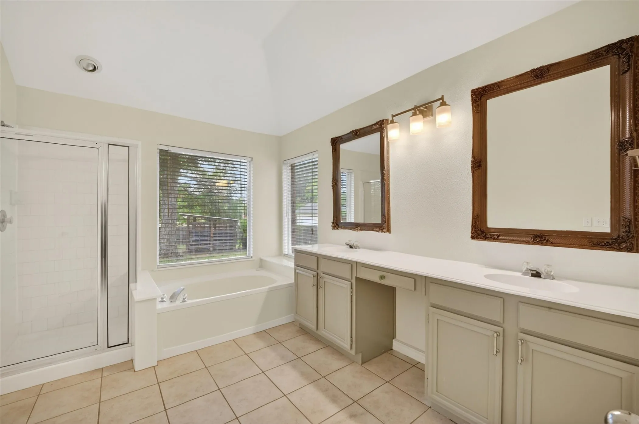 Bathroom featuring a double vanity with light-toned cabinetry, light countertops, and individual framed mirrors