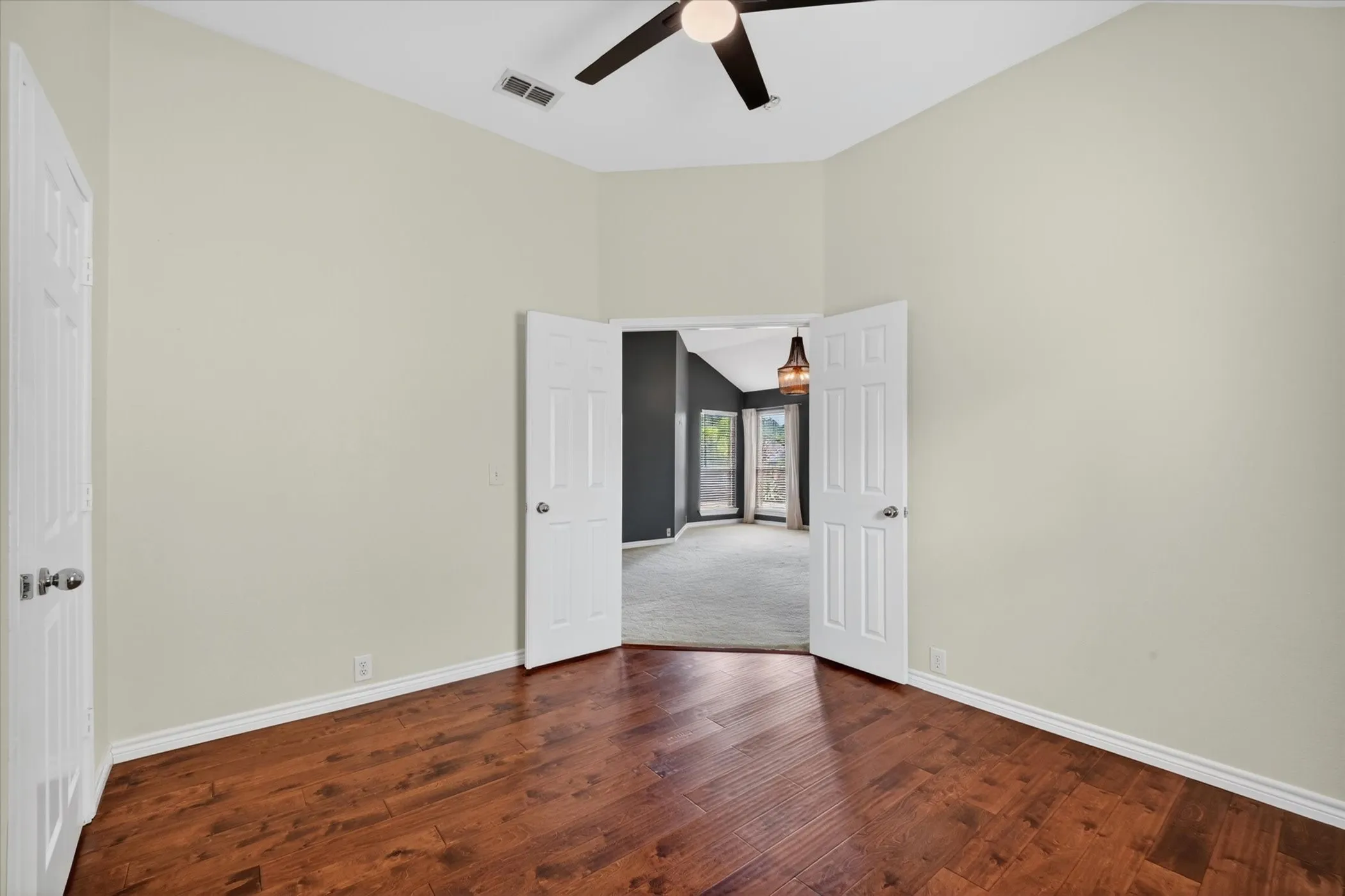 Room featuring wood-finish flooring, vaulted ceiling, and a ceiling fan