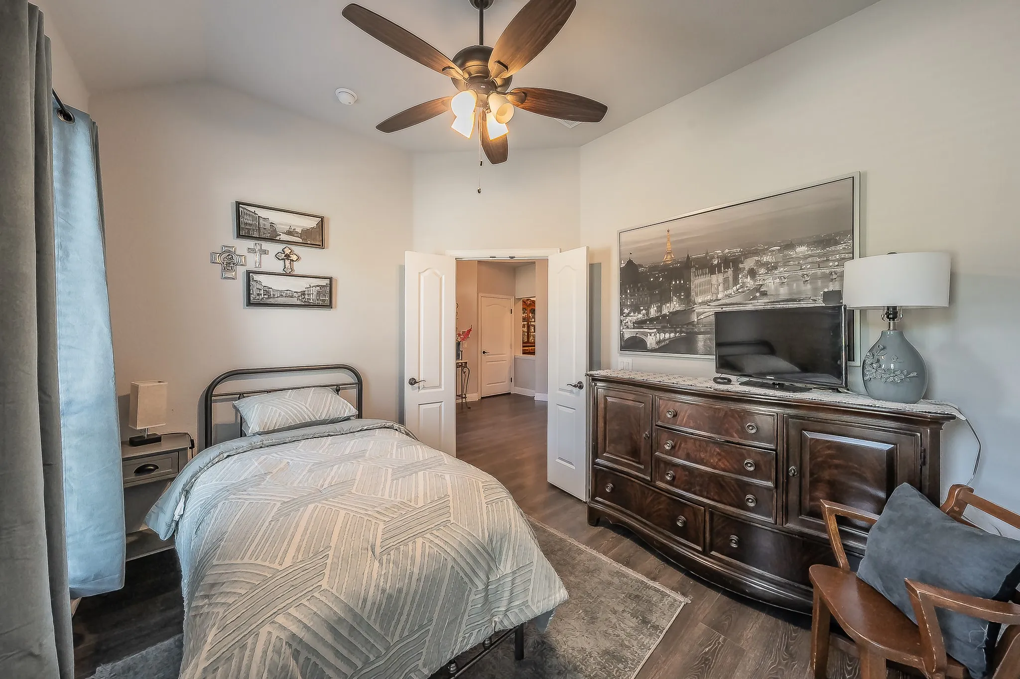 Bedroom featuring vaulted ceilings, wood-finish flooring, and a ceiling fan with integrated lighting