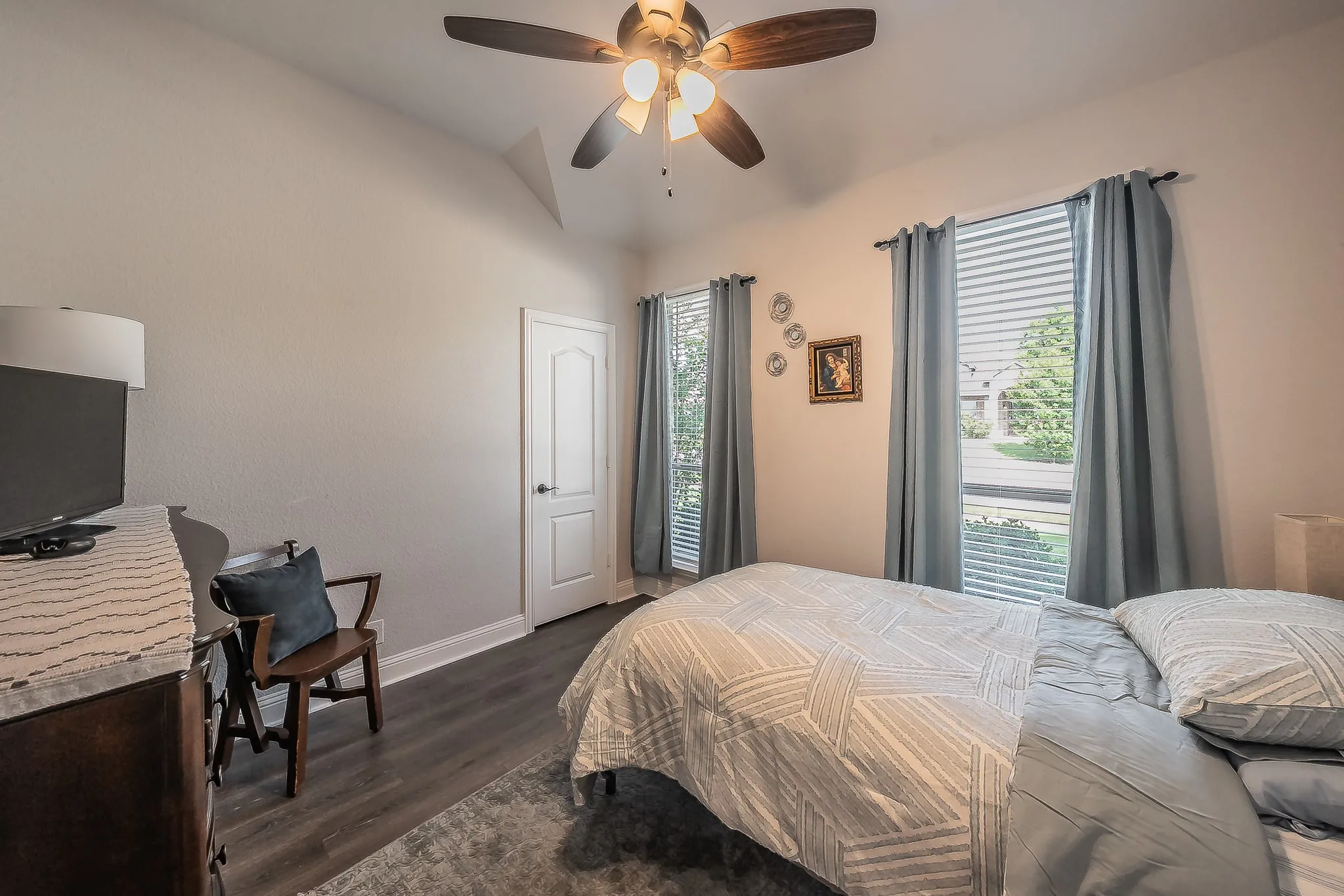 Vaulted ceiling room featuring wood-finish flooring and a ceiling fan with integrated lighting