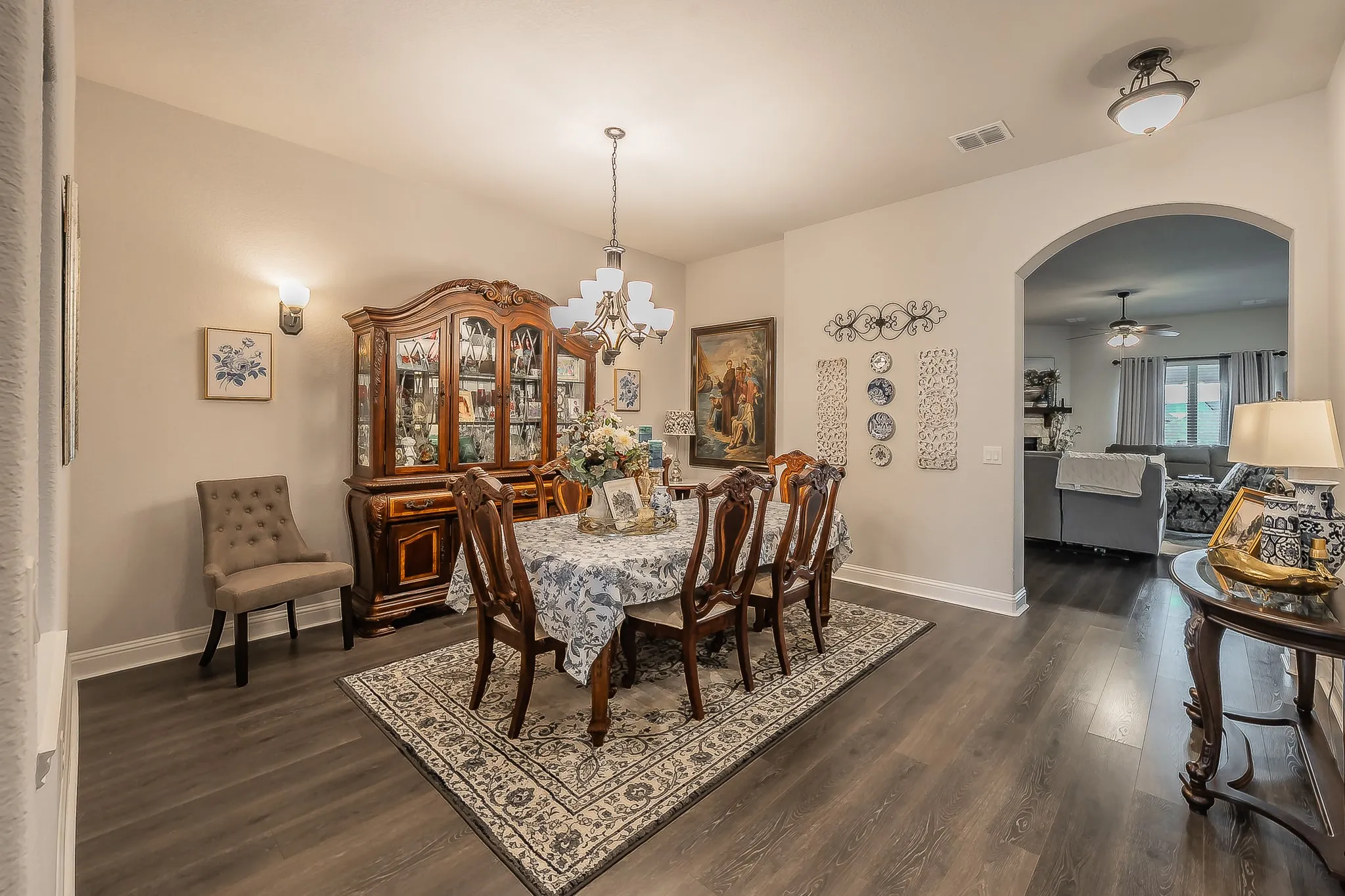Dining area featuring wood-finish flooring, a decorative wall sconce, and a ceiling-mounted chandelier