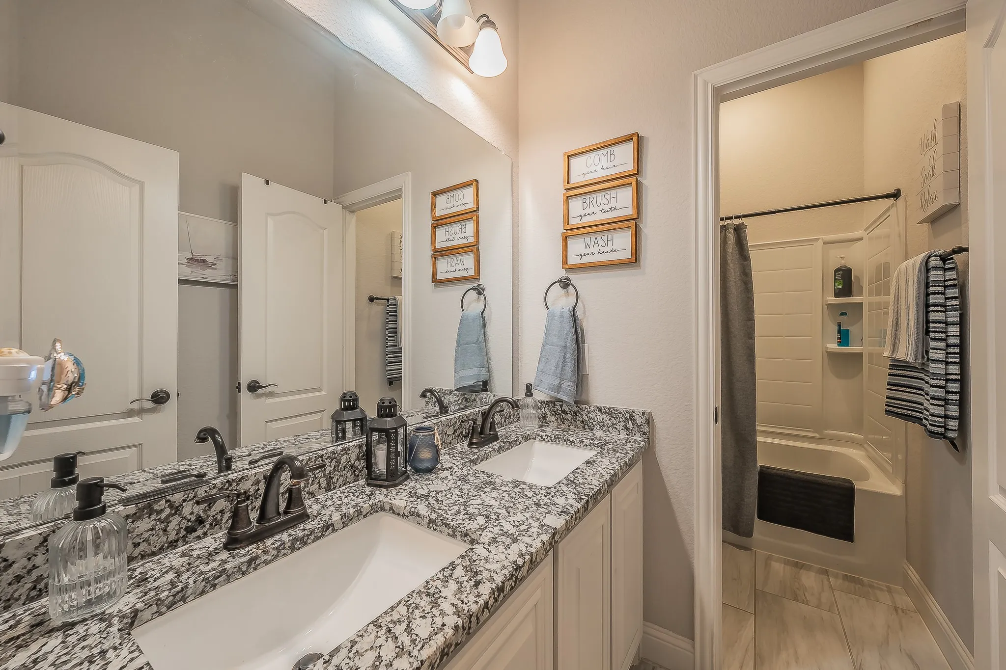 Double vanity with granite countertops, undermount sinks, and oil-rubbed bronze fixtures
