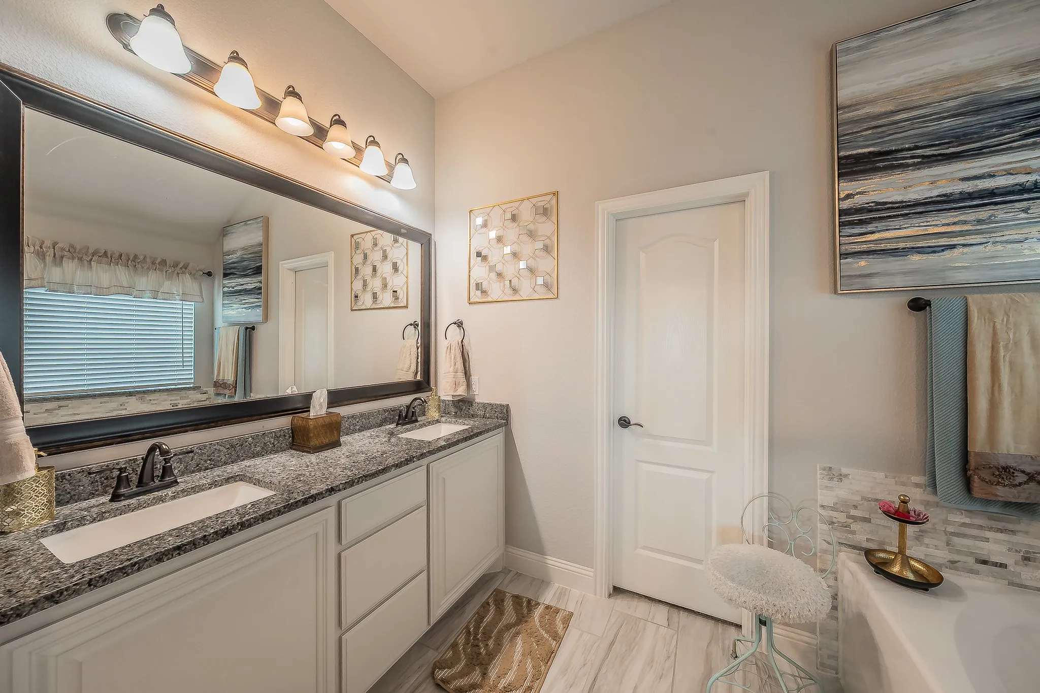 Dual vanity with granite countertops, undermount sinks, and dark bronze fixtures