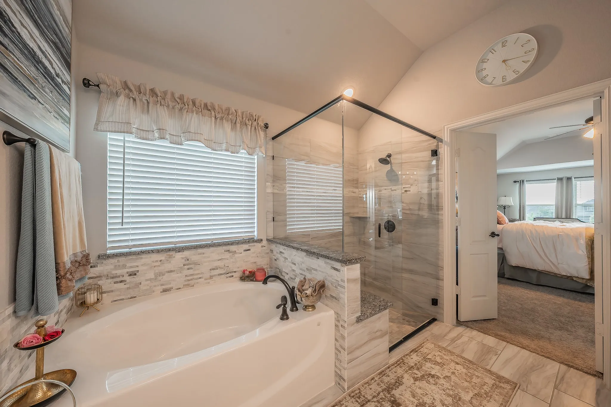 Spacious bathroom featuring a soaking tub, glass-enclosed shower, tile flooring, and a window with horizontal​​‌​​​​‌​​‌‌​‌‌​​​‌‌​‌​‌​‌​​​‌​​ blinds