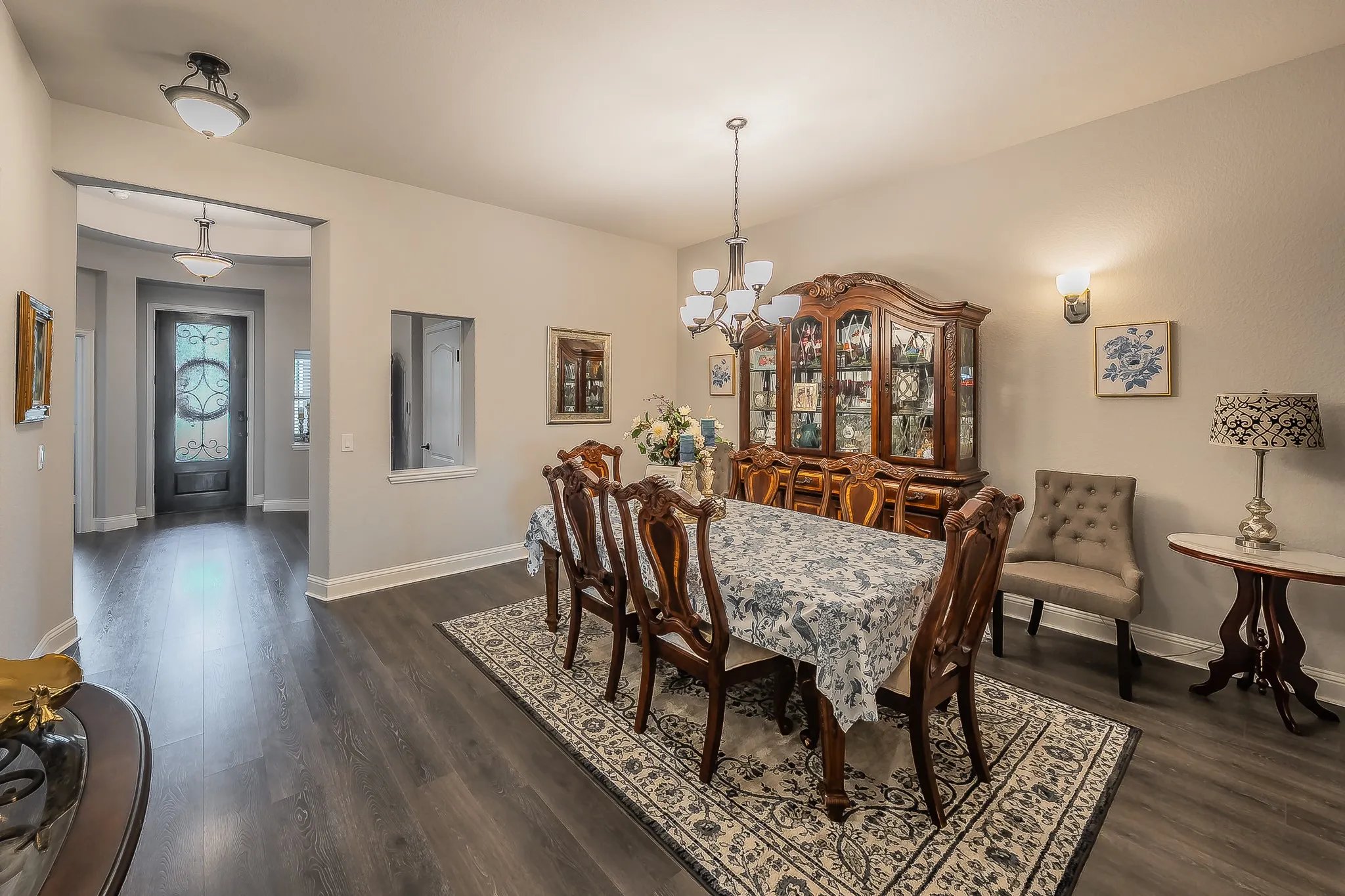 Formal dining space featuring wood-finish flooring, a decorative chandelier, and wall sconces