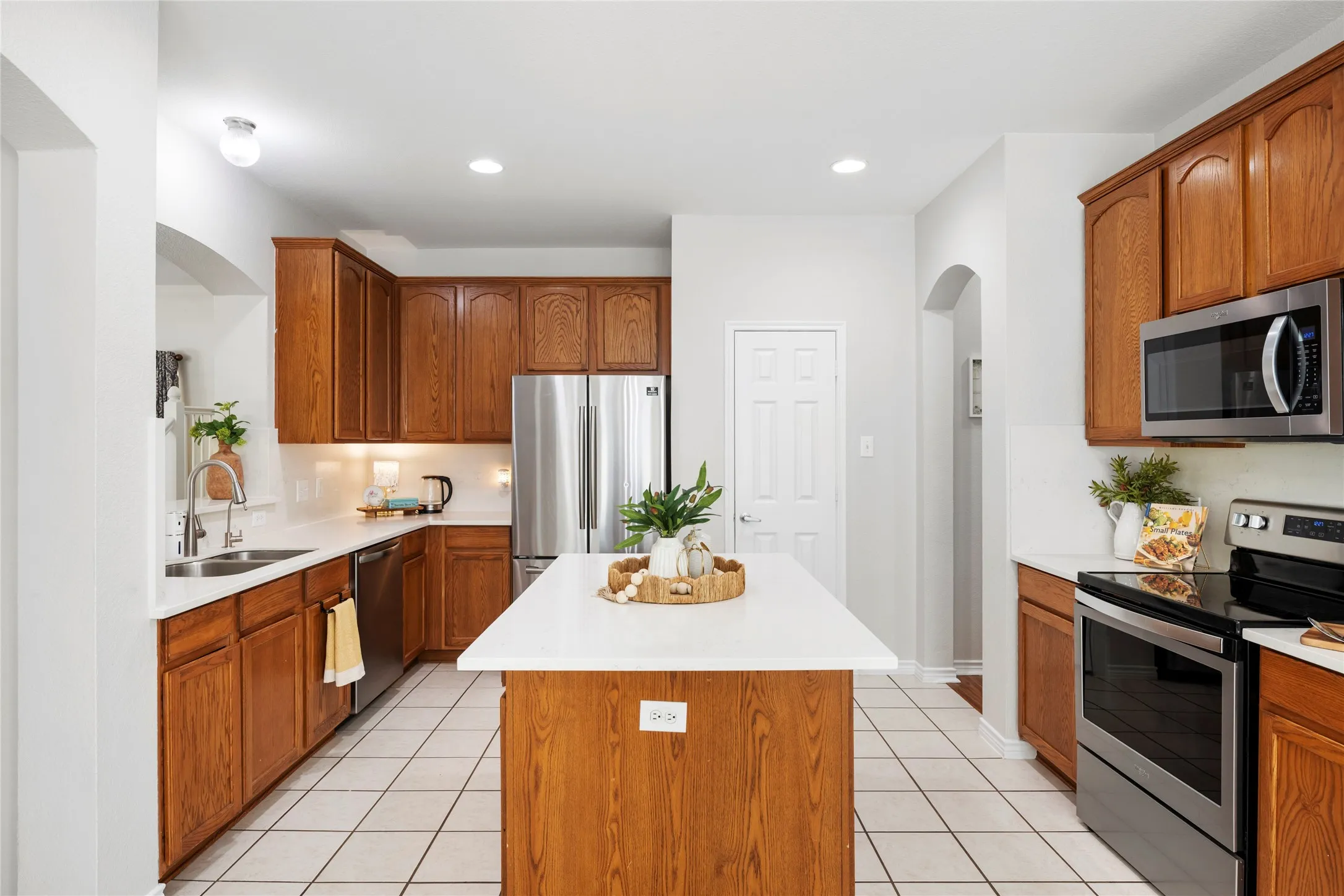  The kitchen features stainless steel appliances, a center island, and a generously sized walk-in pantry with space for a small freezer.