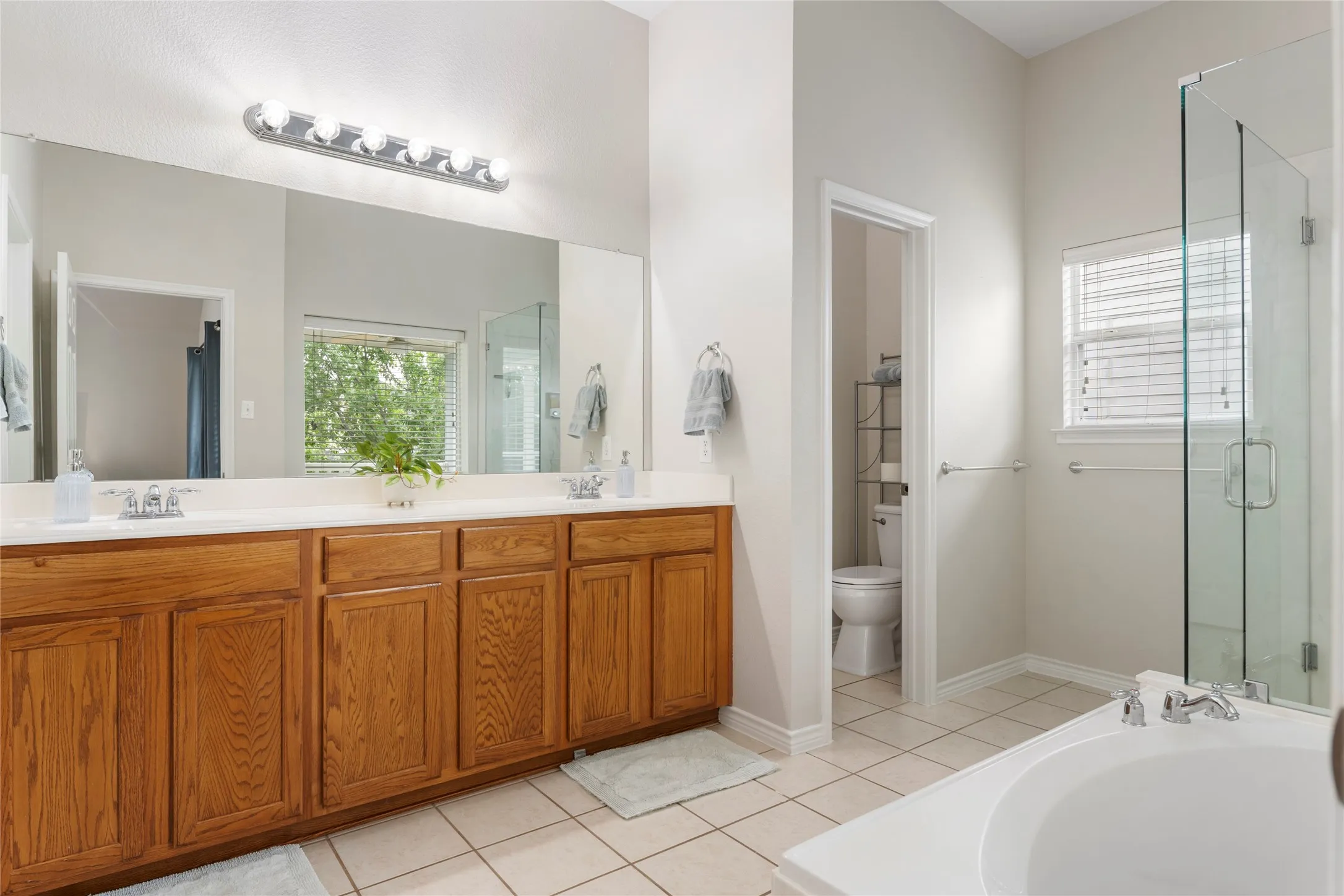The ensuite bath offers dual sinks, a garden tub, a separate shower with frameless glass, and a walk-in closet.