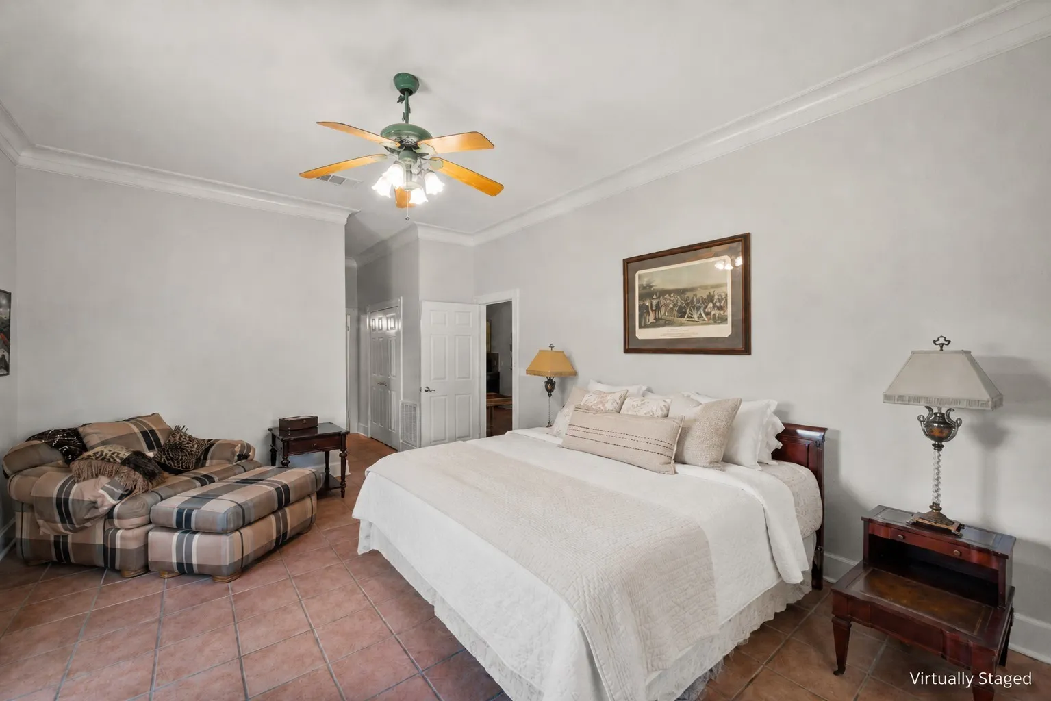 Primary bedroom with farmhouse style, sitting area, tile floors, and peaceful acreage views.