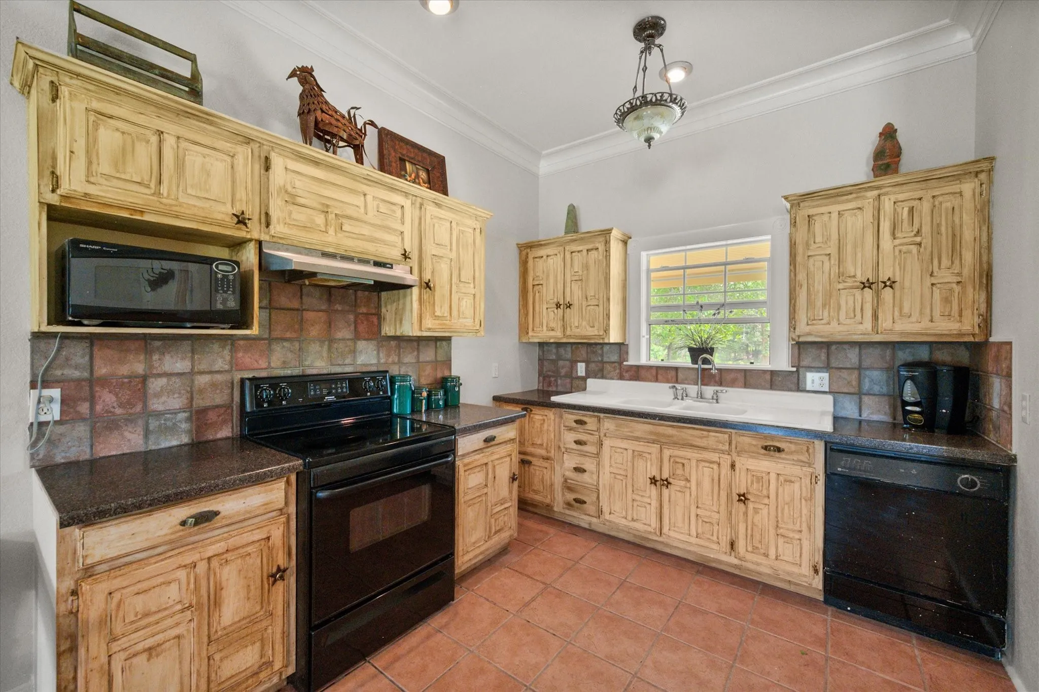 Country kitchen featuring wood cabinets, black appliances, and classic farmhouse character in Kerens TX.