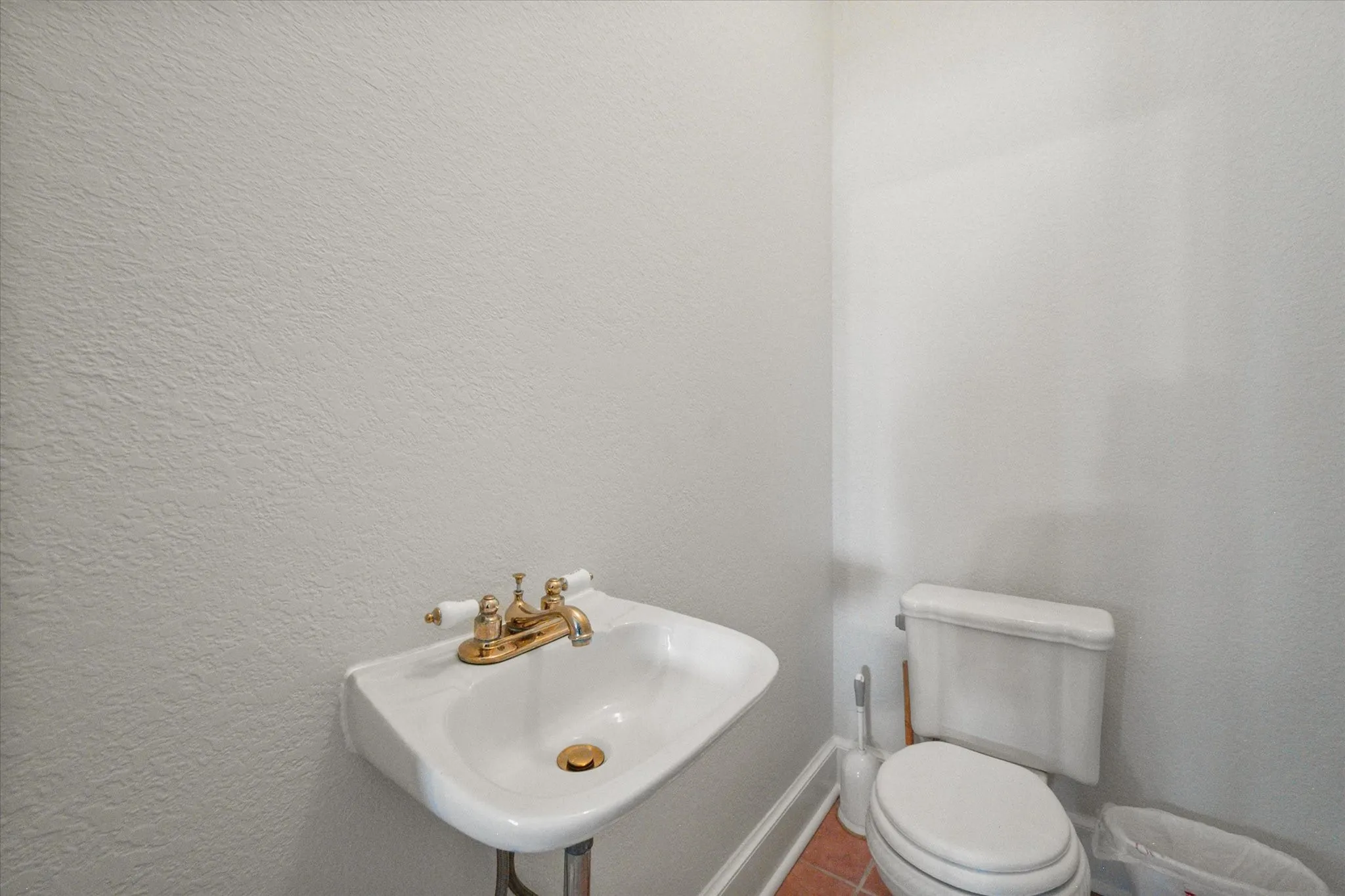 Half bath with pedestal sink, toilet, and simple convenience for guests in this Kerens TX farmhouse.
