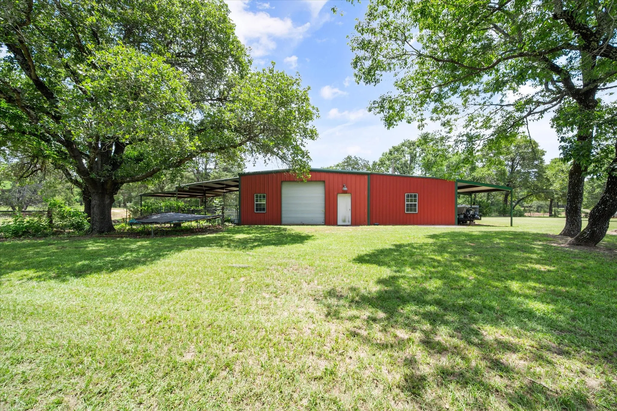 Red barn and open grassy acreage create classic Texas farm and ranch appeal in Kerens TX.