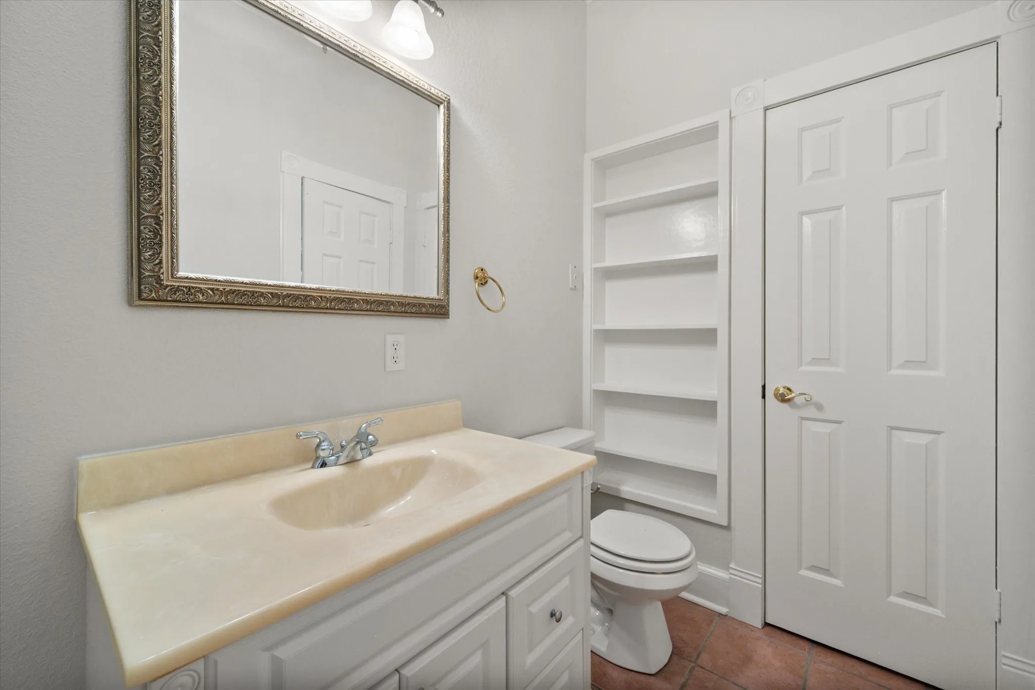 Bathroom vanity with built-in shelving and convenient layout inside this 3-bedroom Kerens farmhouse.