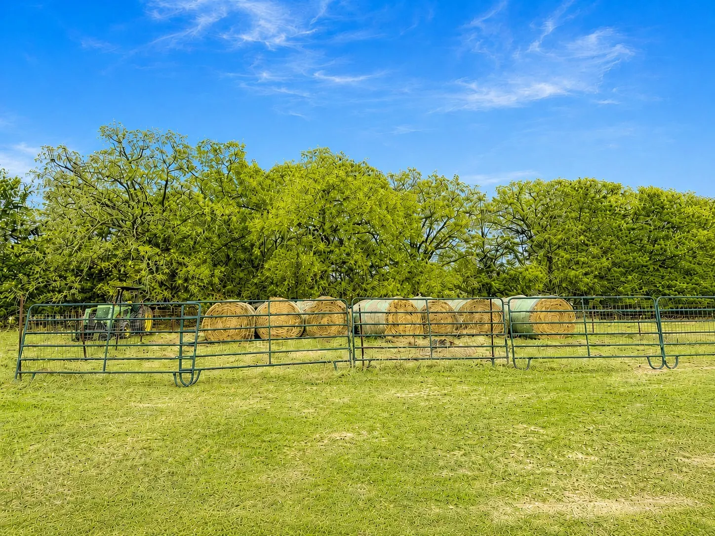 Fenced pasture with hay bales showcases the ranch-ready setup and agricultural potential of this 42-acre Kerens TX farm and country property.