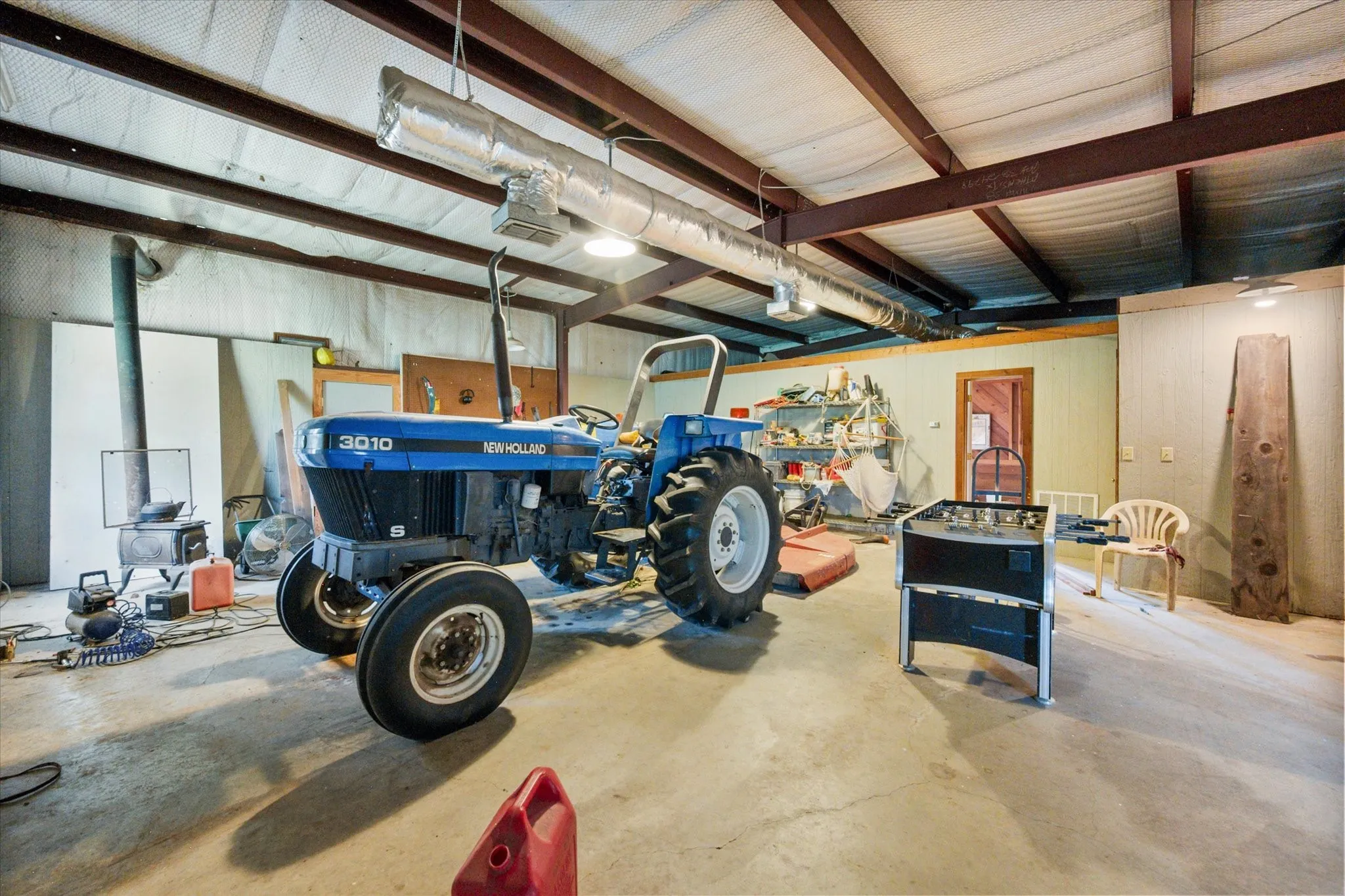 Large workshop with concrete floor, equipment storage, and flexible ranch utility space on 42 acres.