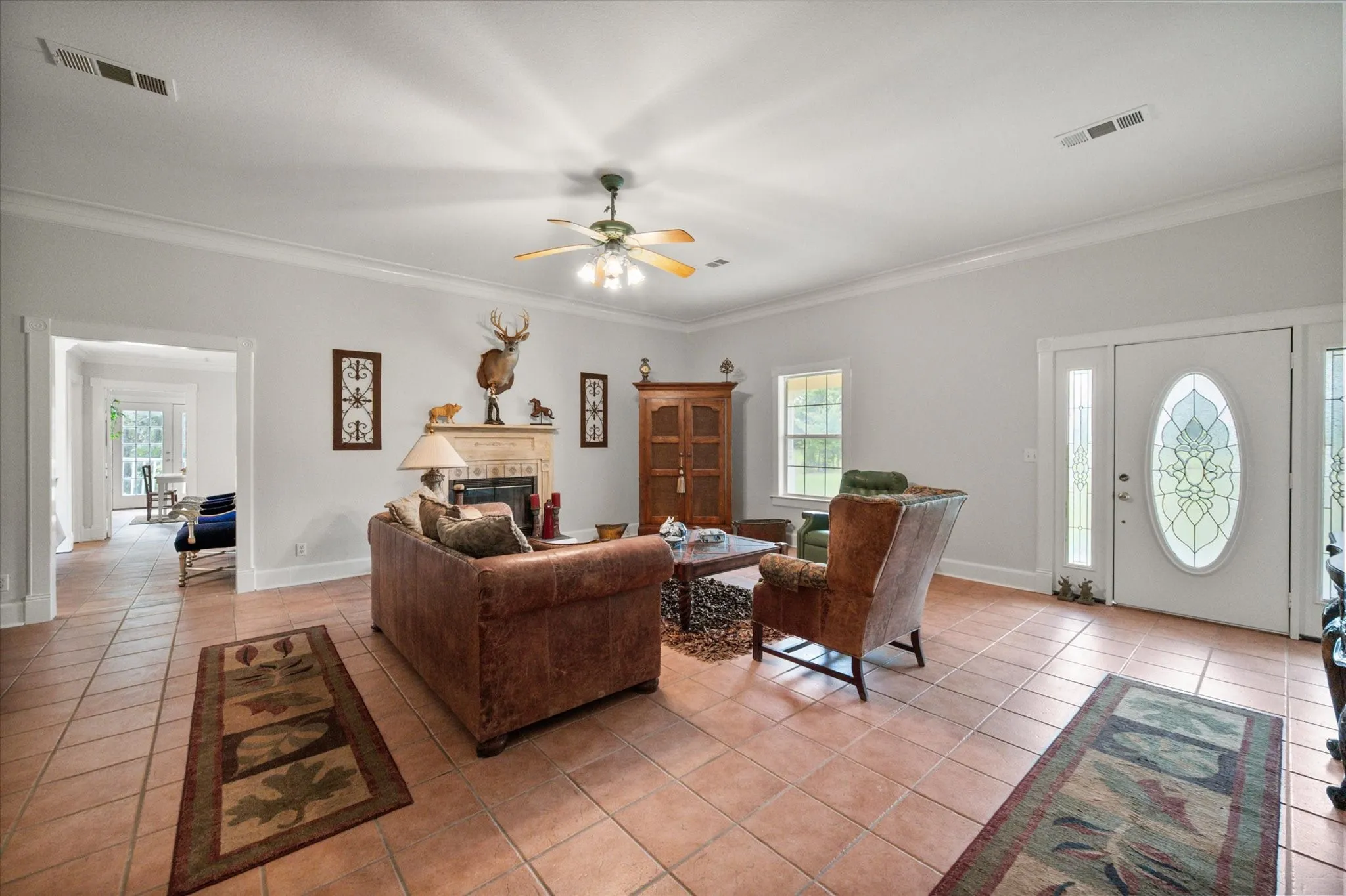 Open living area with natural light, tile flooring, and comfortable farmhouse layout on 42 acres in Kerens TX.