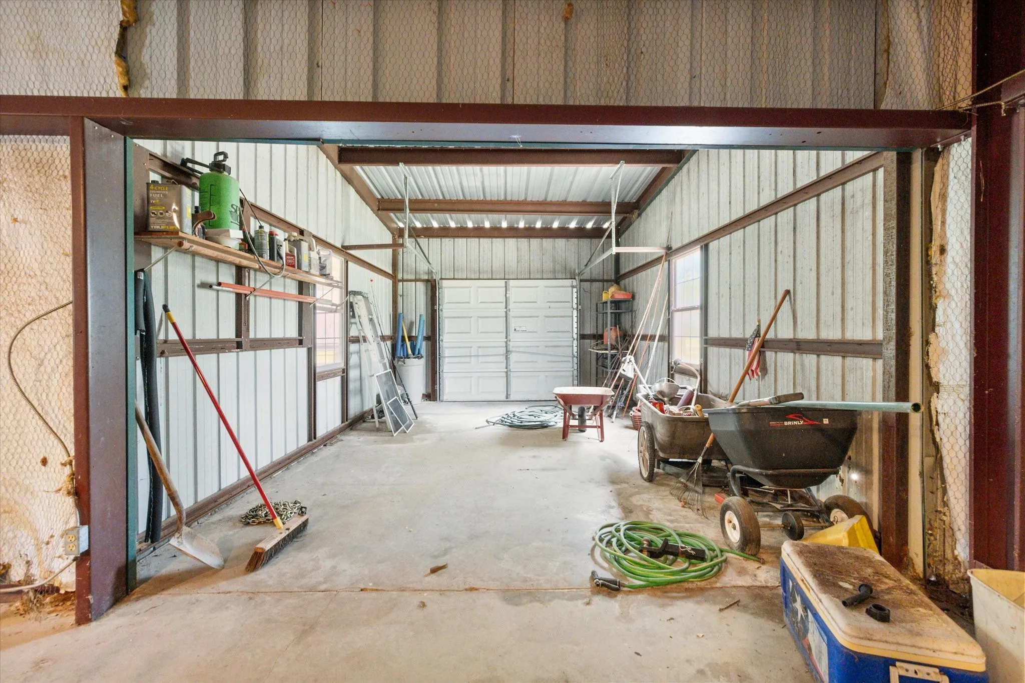 Barn interior with stalls, storage, and ranch infrastructure for livestock, horses, or equipment.