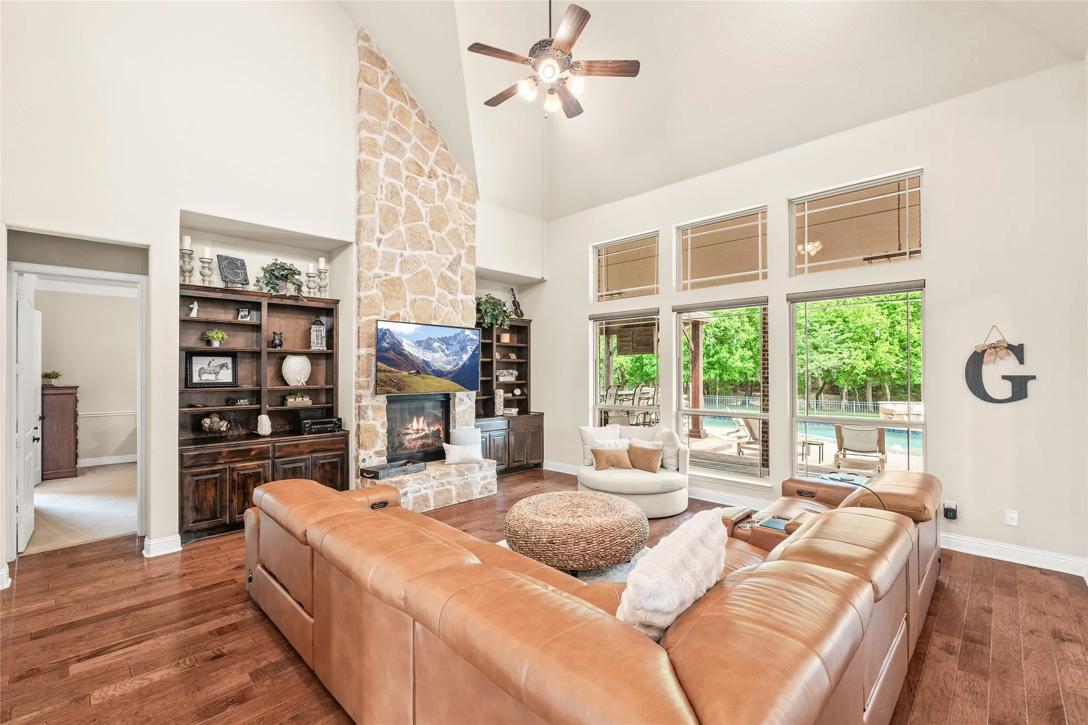 family room with built in cabinets, gas fireplace, and high ceilings