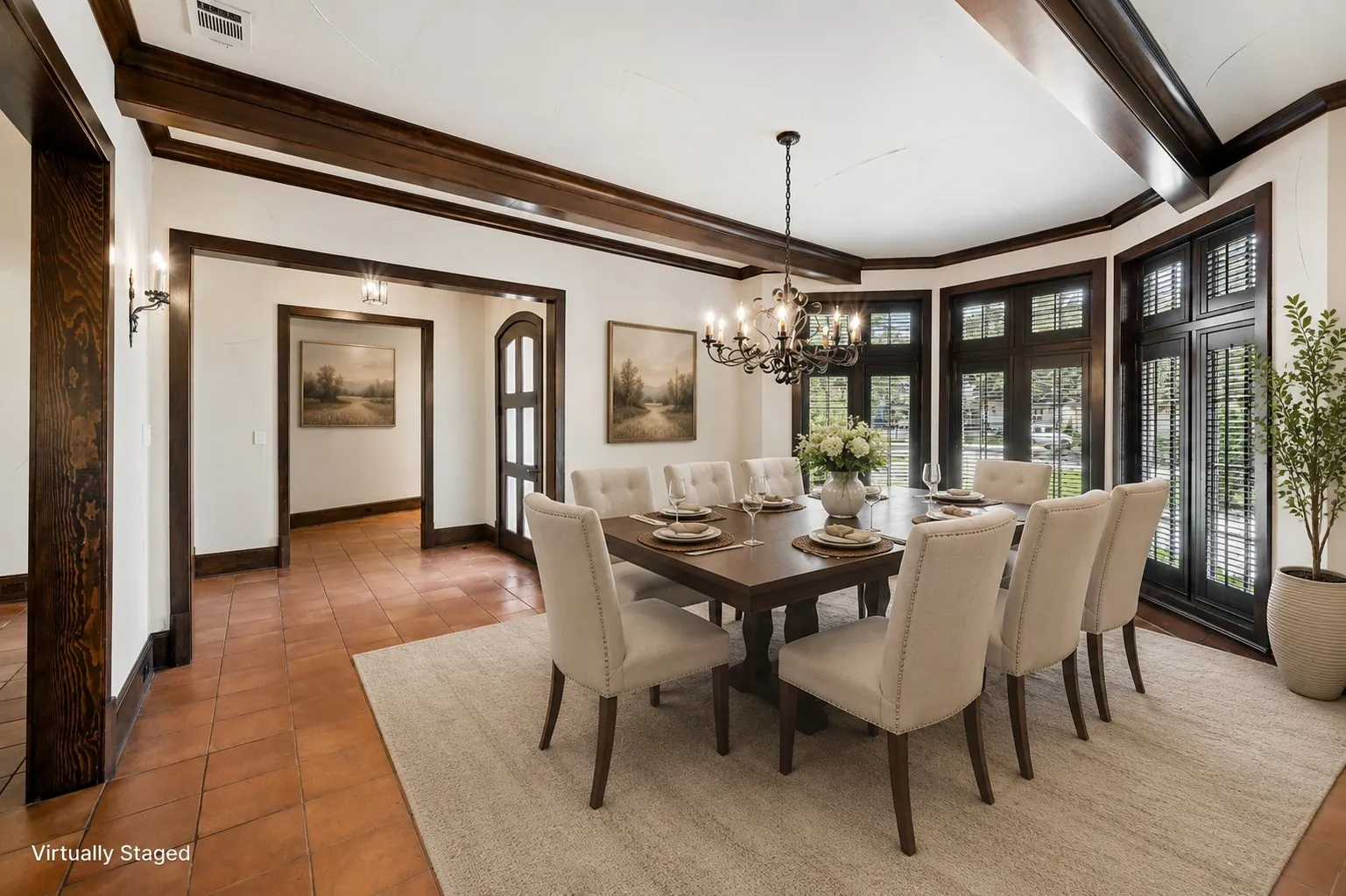 Formal dining area featuring a prominent chandelier, wood-beam ceiling, and rich wood trim