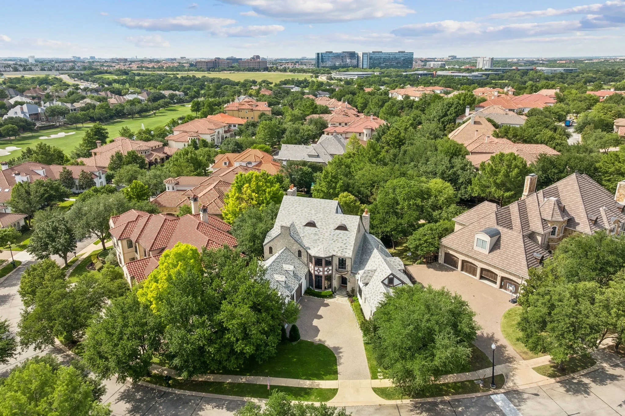 Aerial perspective showcasing a sprawling residential property featuring a multi-gabled slate roof and an intricate facade with dark timber accents