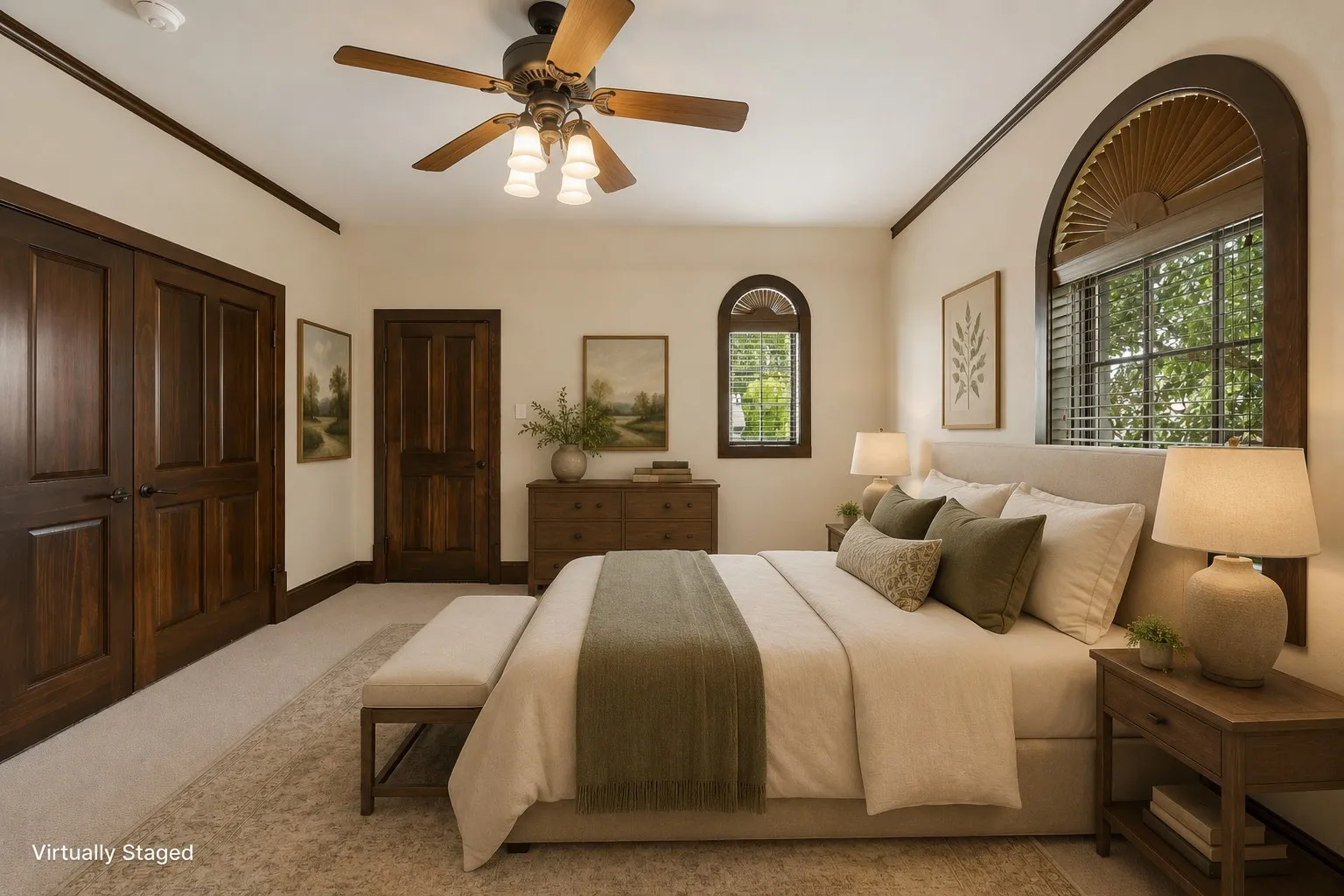 Second floor bedroom featuring a ceiling fan with integrated lighting, a large arched window with interior shutters, a smaller arched window, and wood-paneled doors with dark hardware