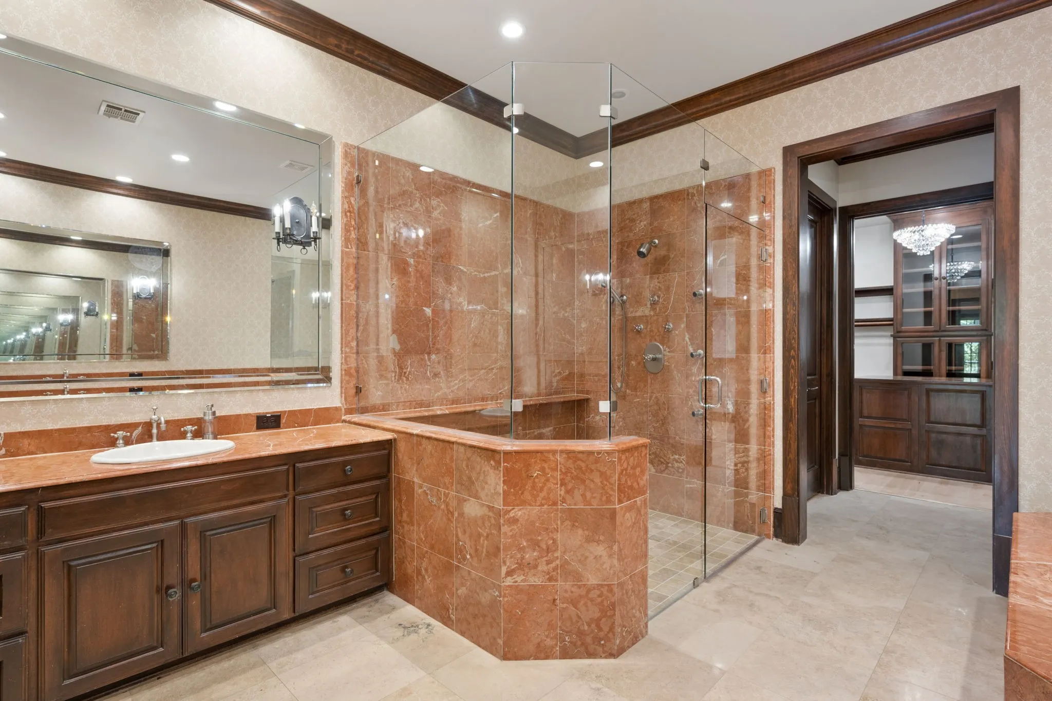 Bathroom featuring a large vanity with wood cabinetry, a single basin, and a red marble countertop