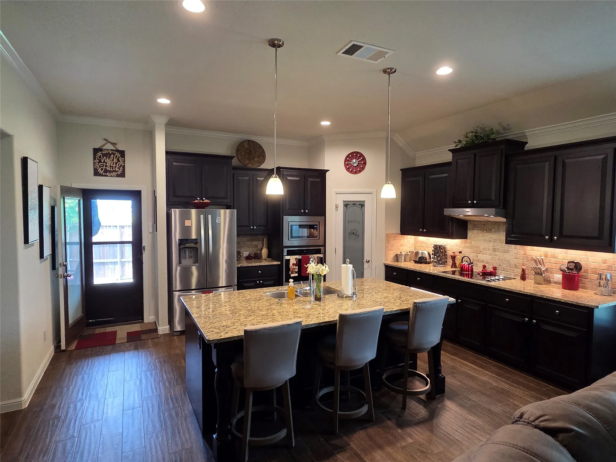 Large Island, under cabinet lighting, and crown molding
Fridge stays with the home