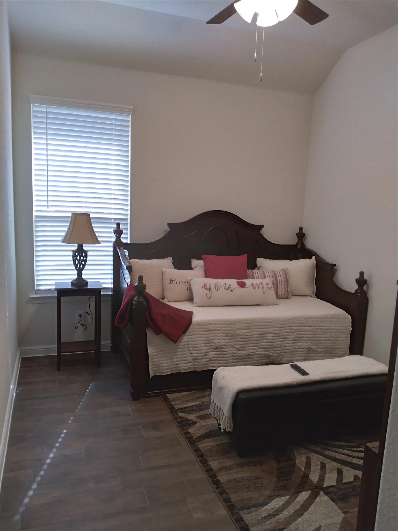 Room featuring wood-finish flooring, a window with blinds, and a ceiling fan with integrated lighting