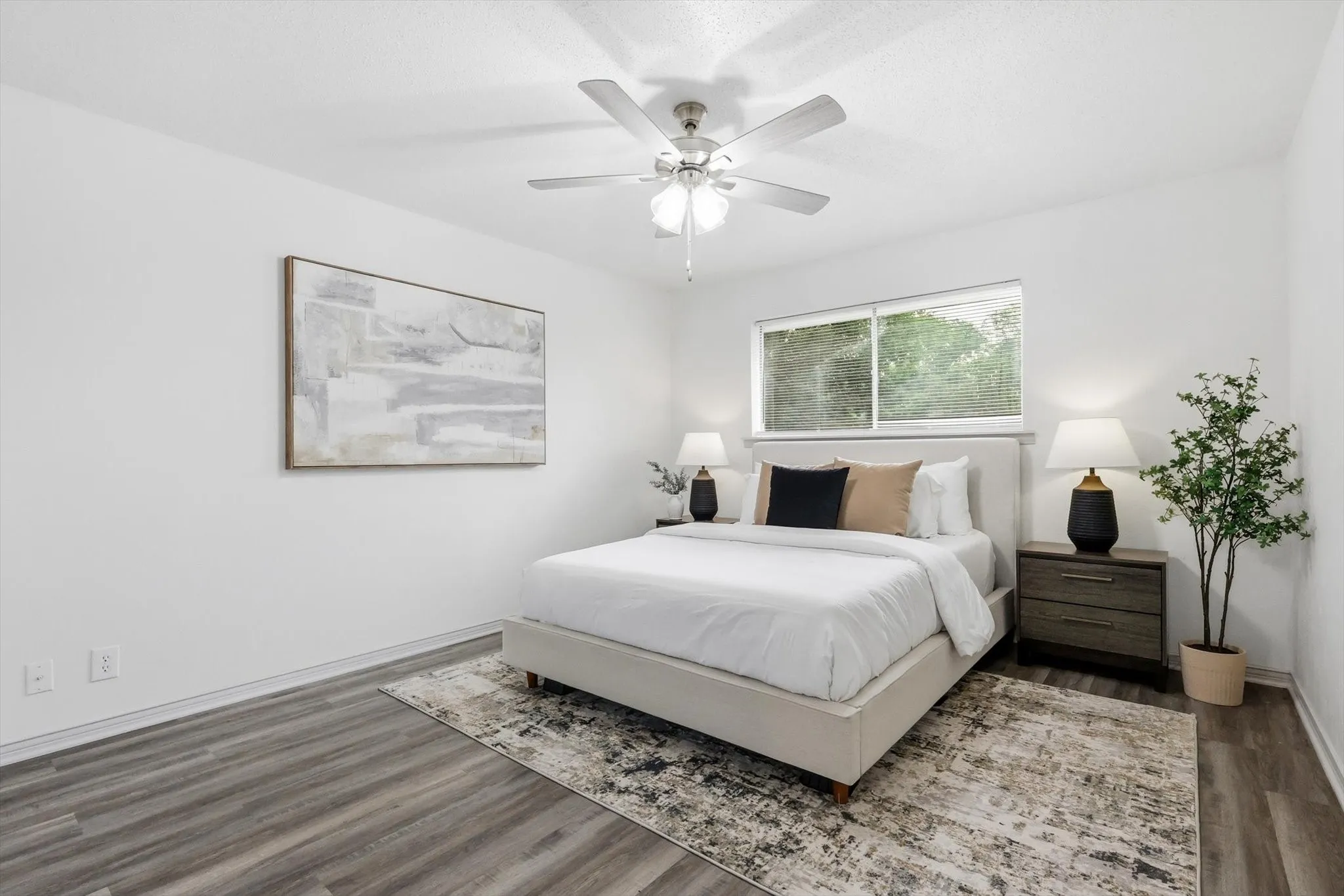 Spacious bedroom featuring wood-finish flooring, a ceiling fan, and a large window
