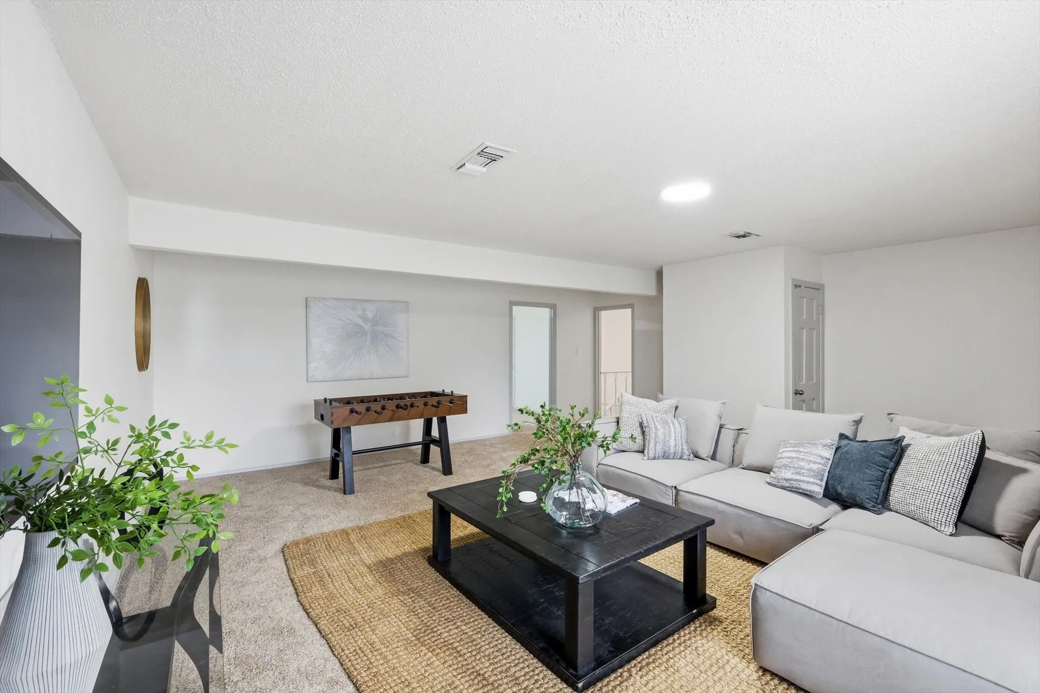 Carpeted living area featuring white walls and a white ceiling
