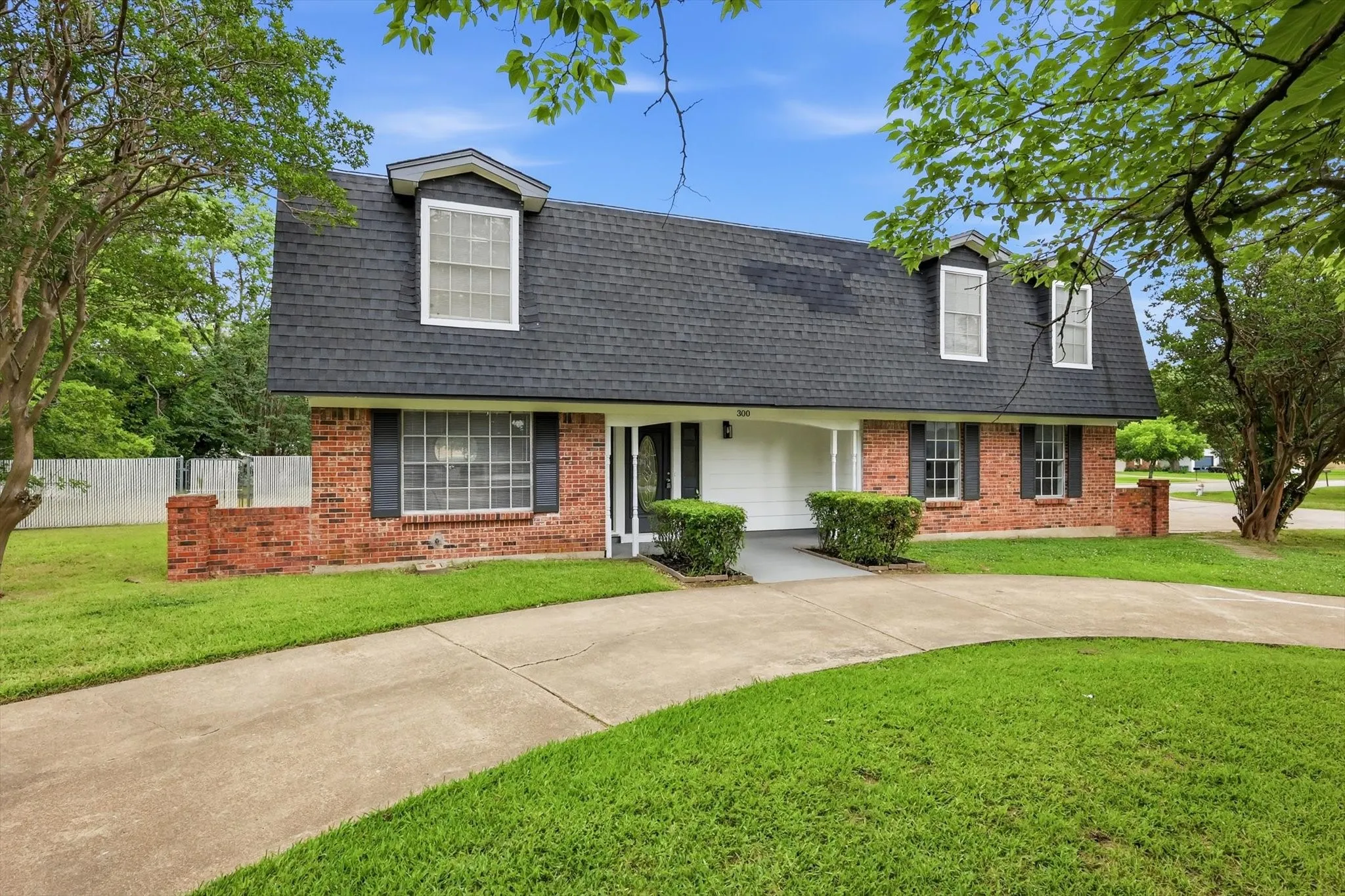 Red brick facade with black shutters and a gambrel roof