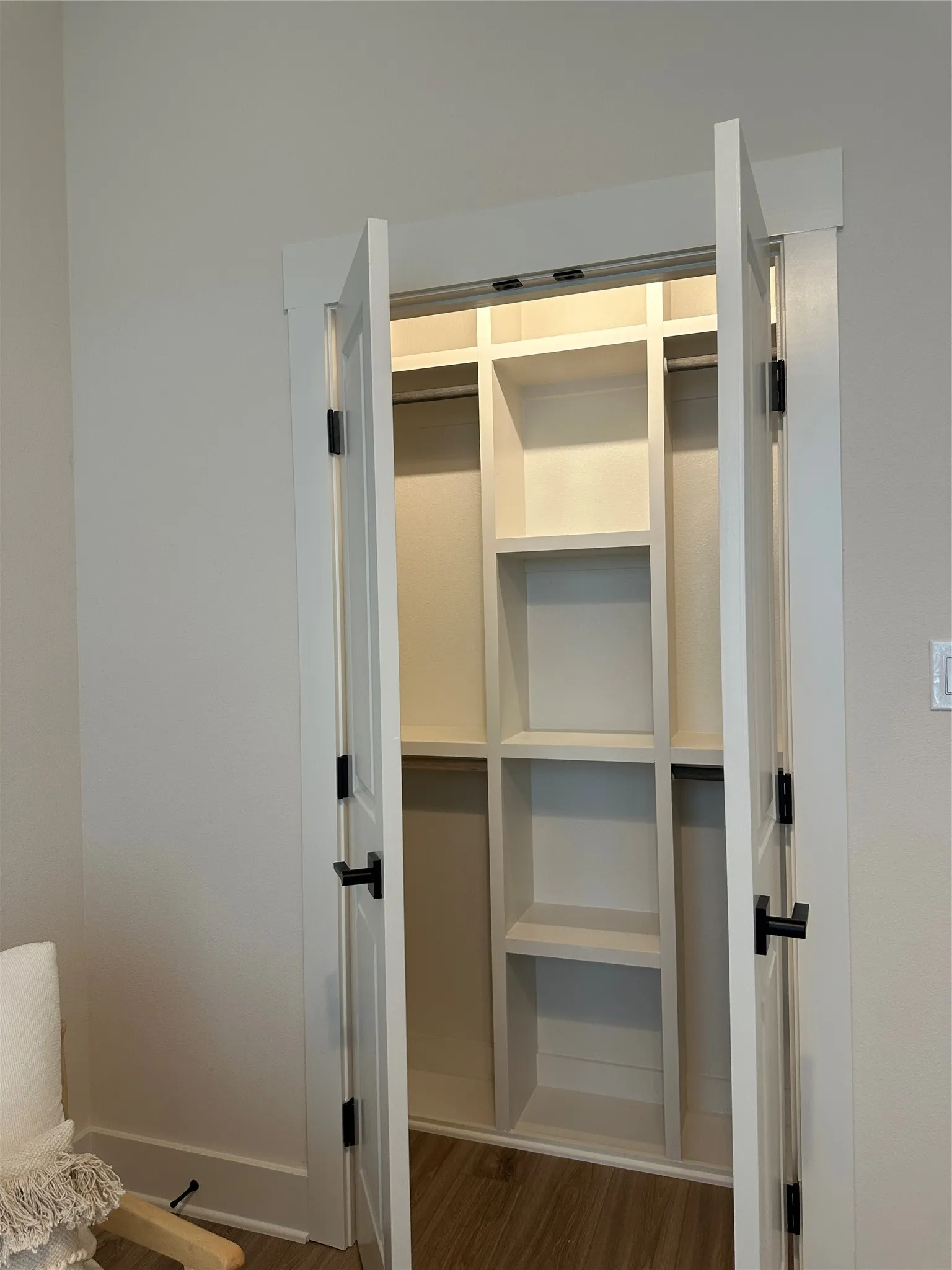 Built-in closet system featuring white shelving and hanging rods