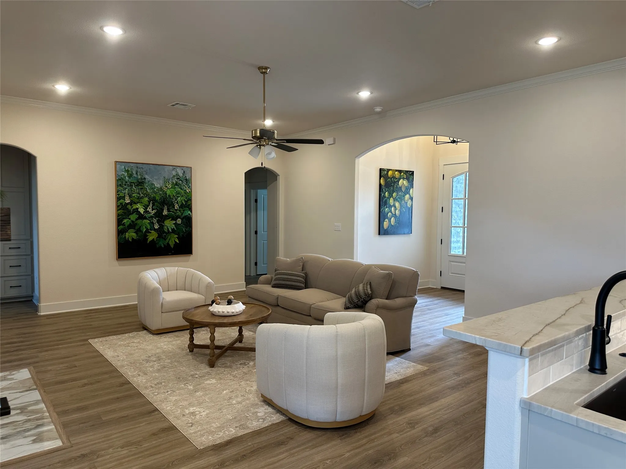 Spacious living area featuring wood-finish flooring, recessed lighting, and crown​​‌​​​​‌​​‌‌​‌‌​​​‌‌​‌​‌​‌​​​‌​​ molding