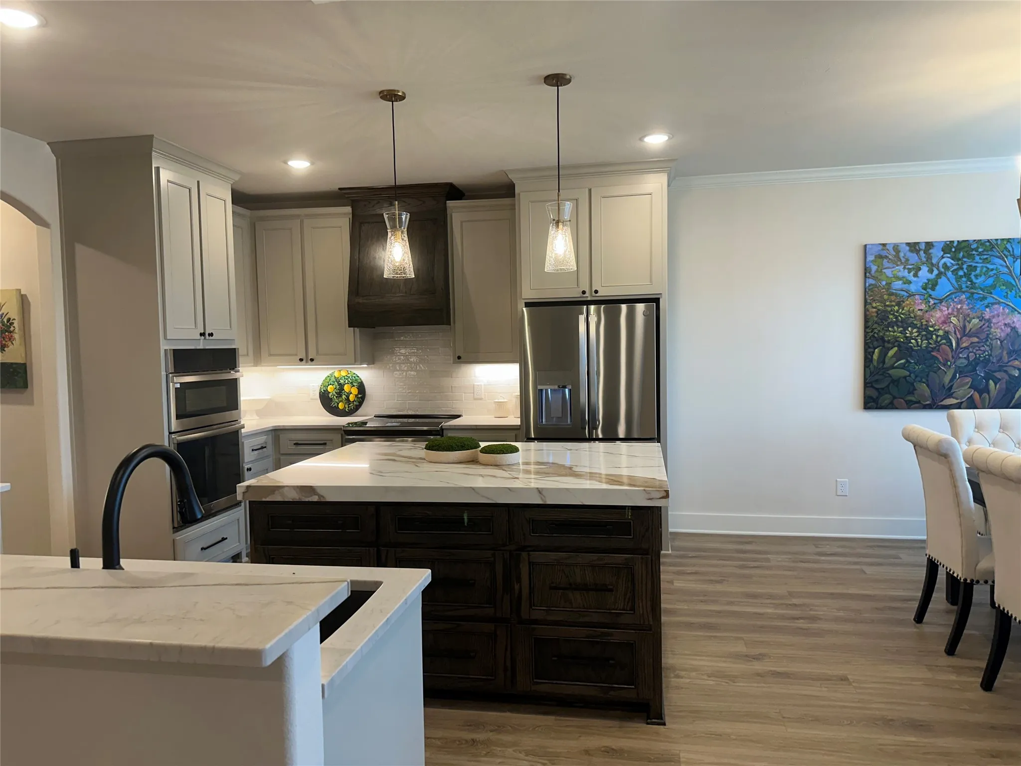 Modern kitchen featuring a large central island with a stone countertop and dark wood cabinetry