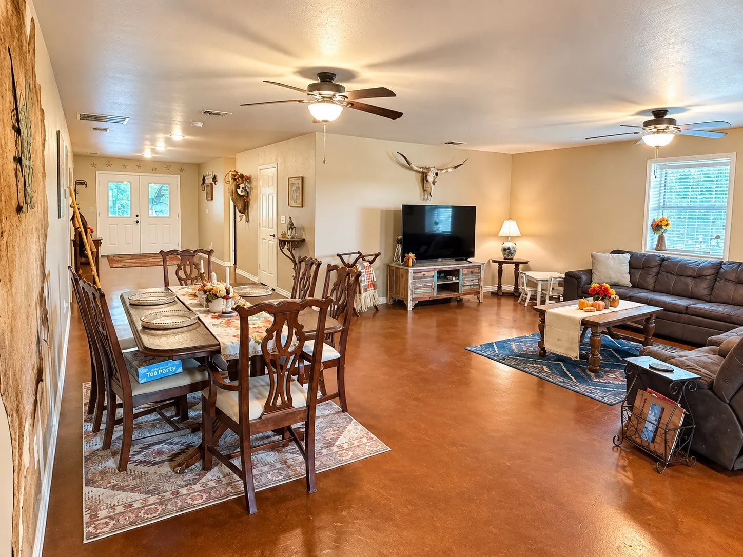 Amazing large open floor plan featuring rich-toned flooring, multiple ceiling fans, recessed lighting, and a double-door entryway