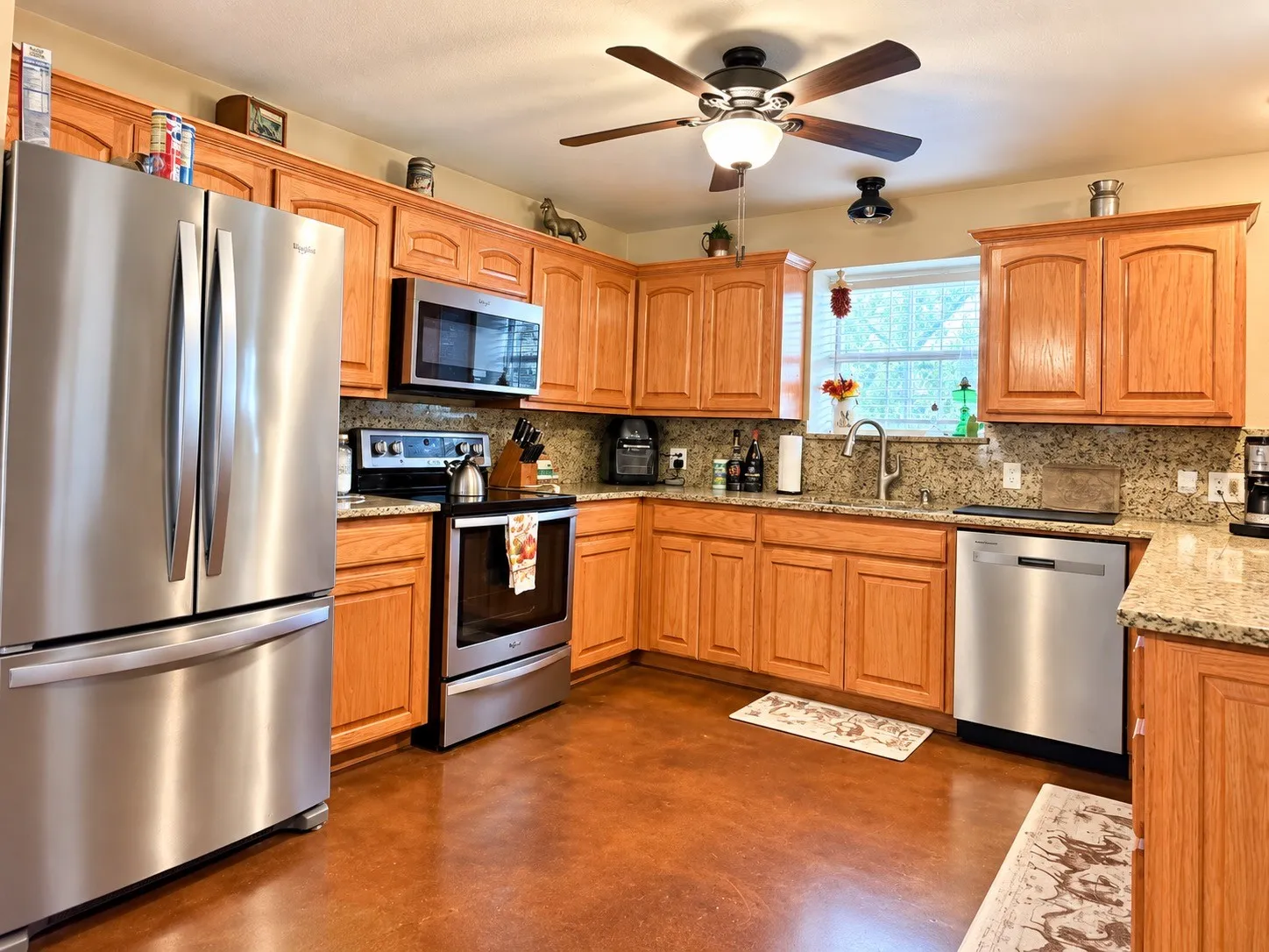 Kitchen featuring wood cabinetry, stainless steel appliances, granite countertops