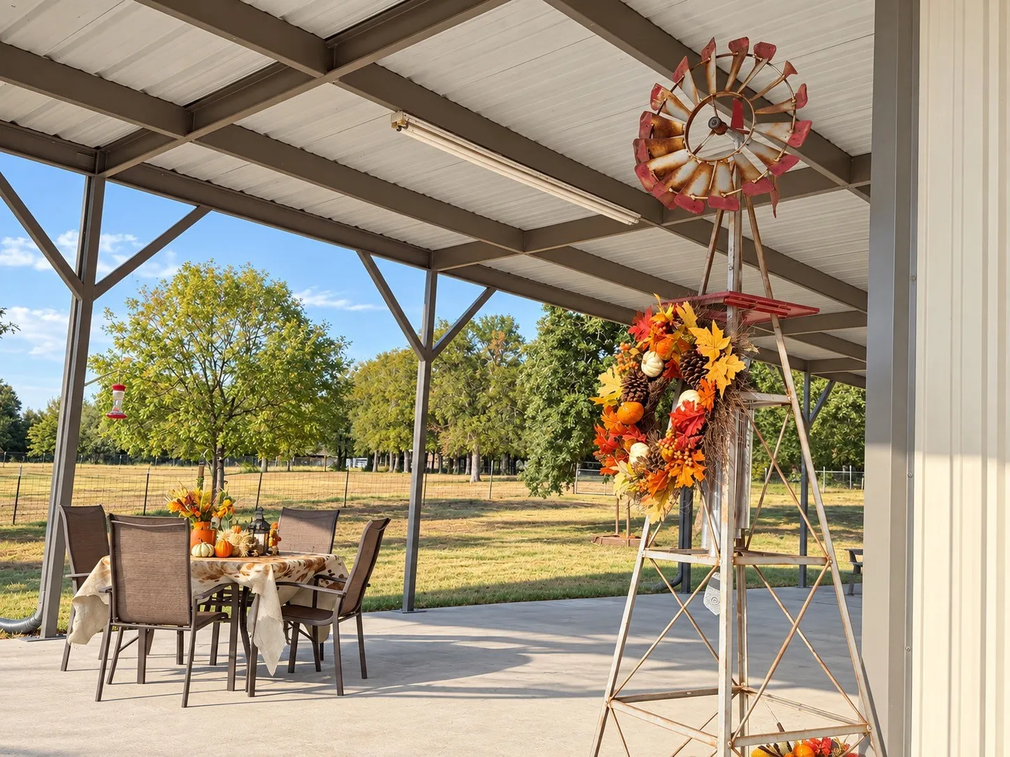 Covered patio for family and entertaining enjoyment with a corrugated metal roof, supported by metal beams, featuring an expansive outdoor area
