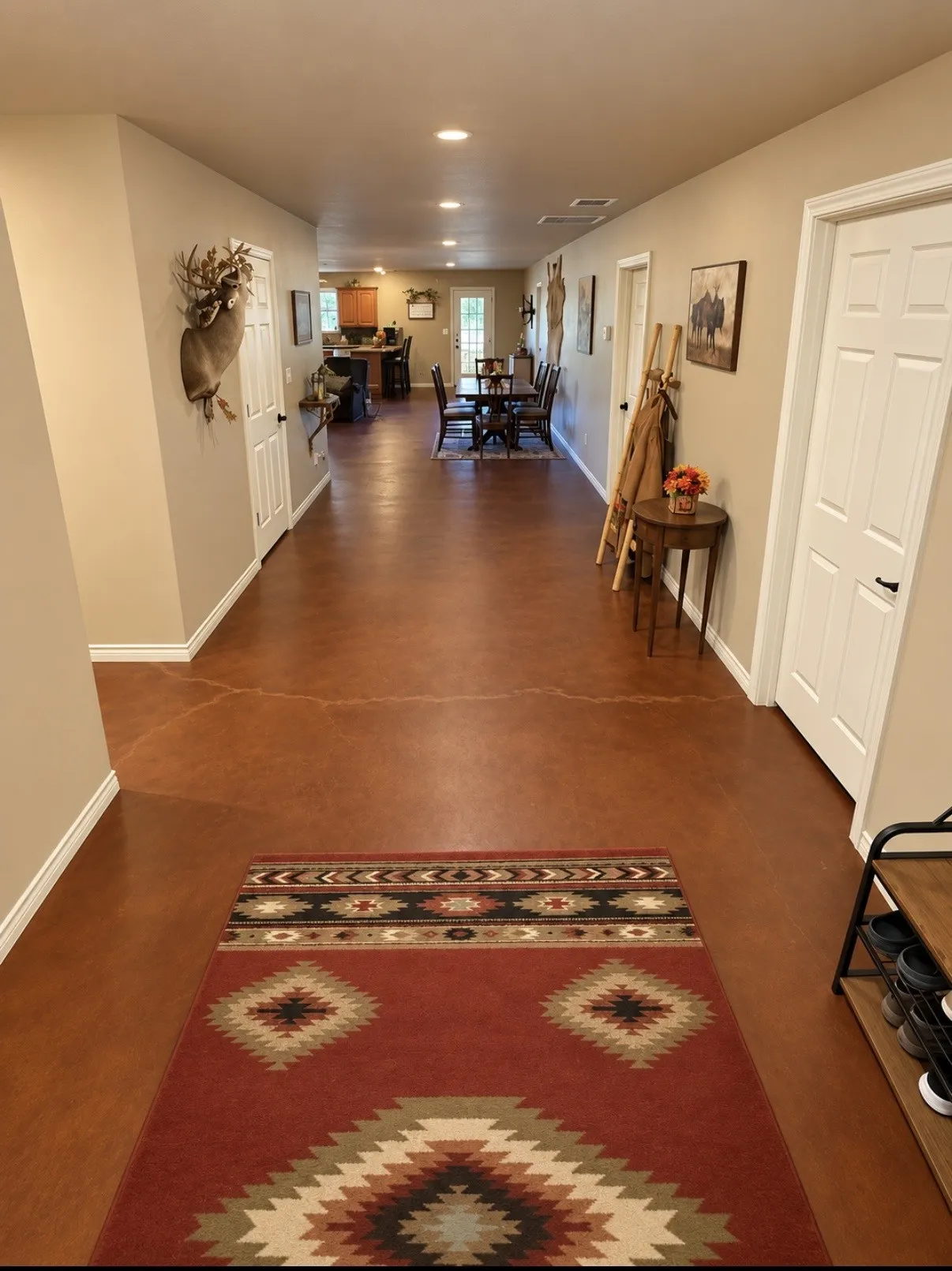 Expansive hallway featuring stained concrete flooring, recessed lighting, and white paneled doors