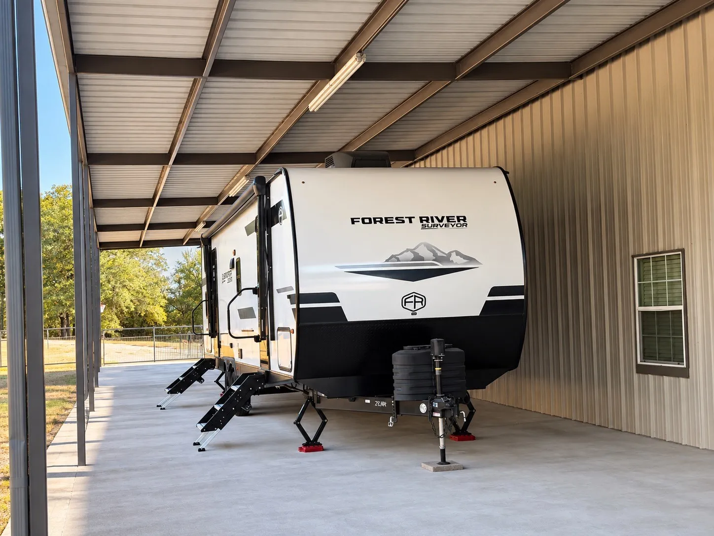 Covered RV parking  with concrete flooring and corrugated metal roofing, So many uses for this space!
