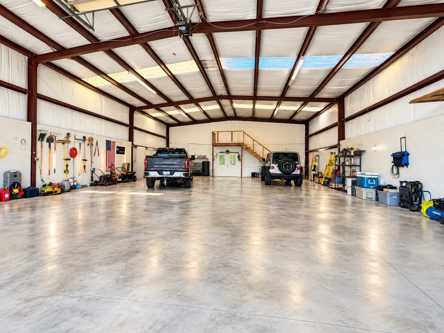 Interior space featuring a concrete floor, exposed structural beams, and translucent ceiling panels endless uses.