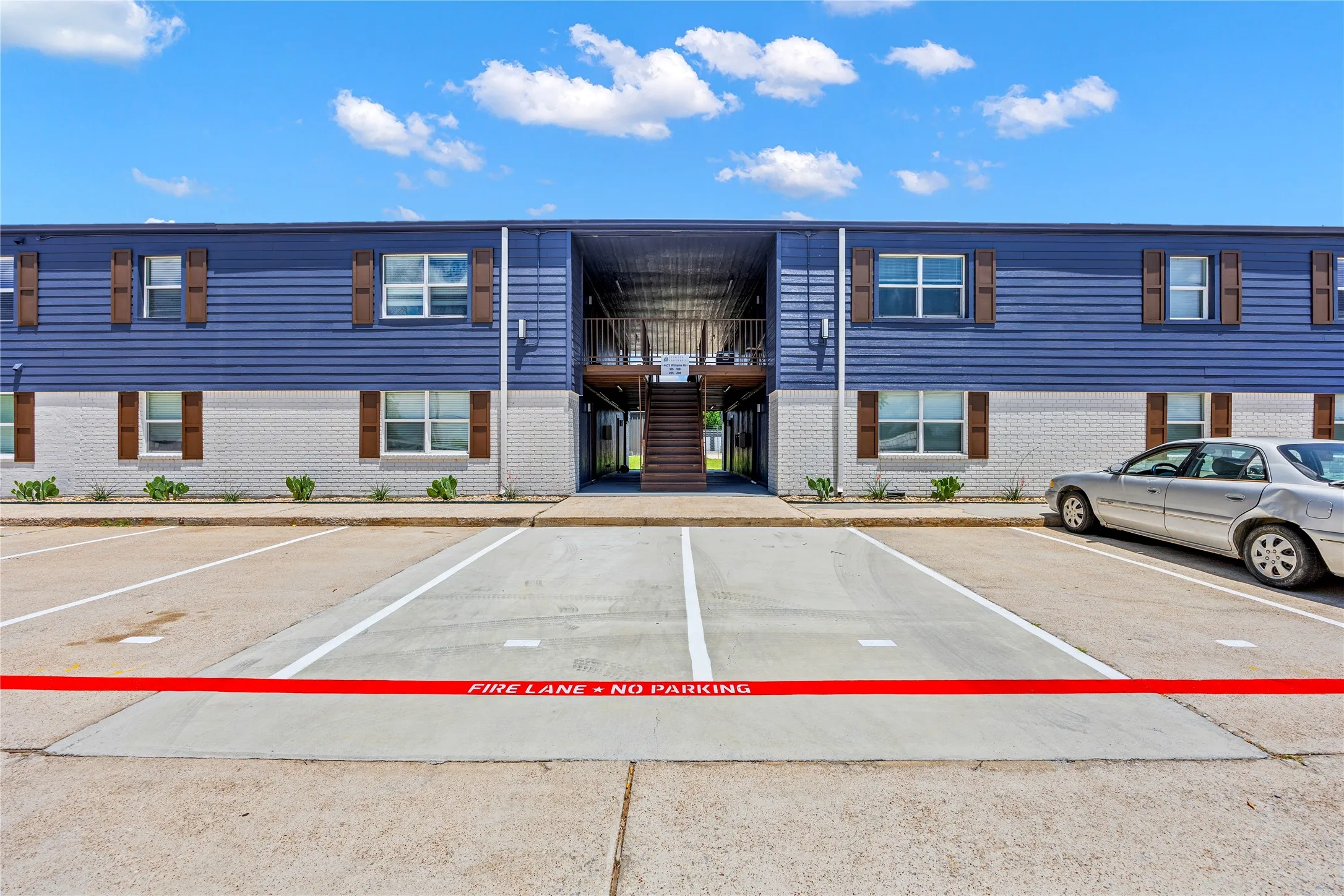 View of building exterior featuring uncovered parking and stairs