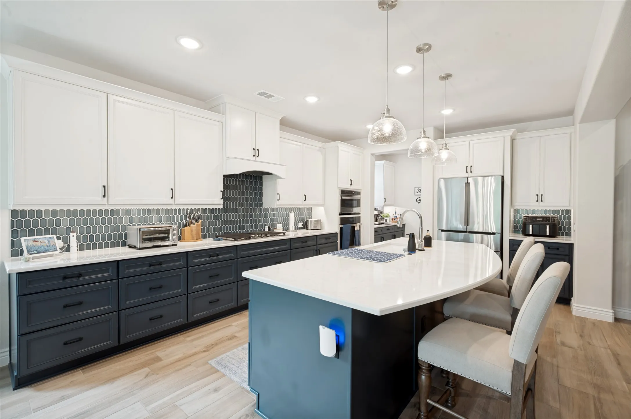 Navy Blue Lower Cabinets and a complimentary Navy Blue Backsplash.