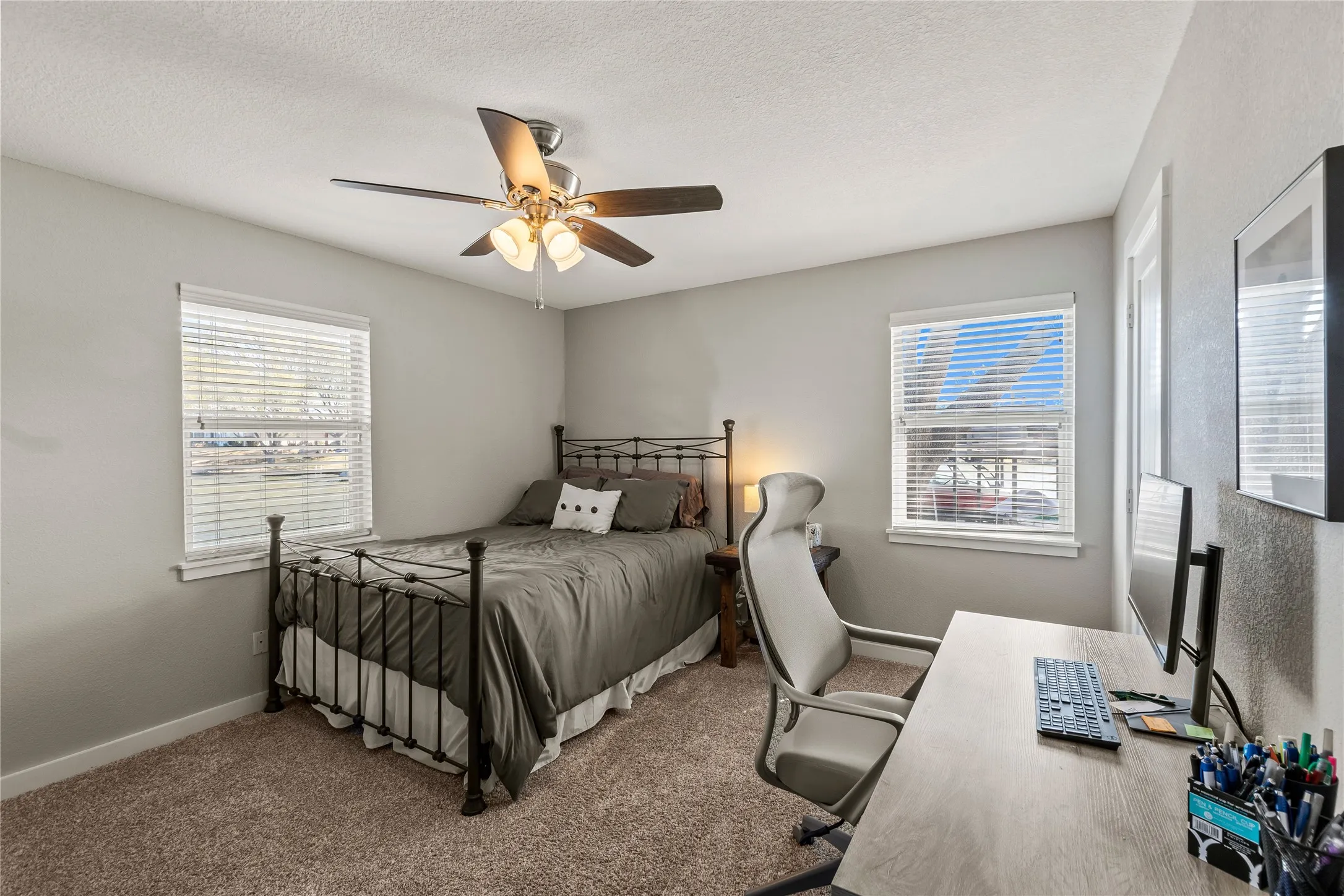 Bedroom featuring carpet flooring, multiple windows, a ceiling fan, and a textured ceiling