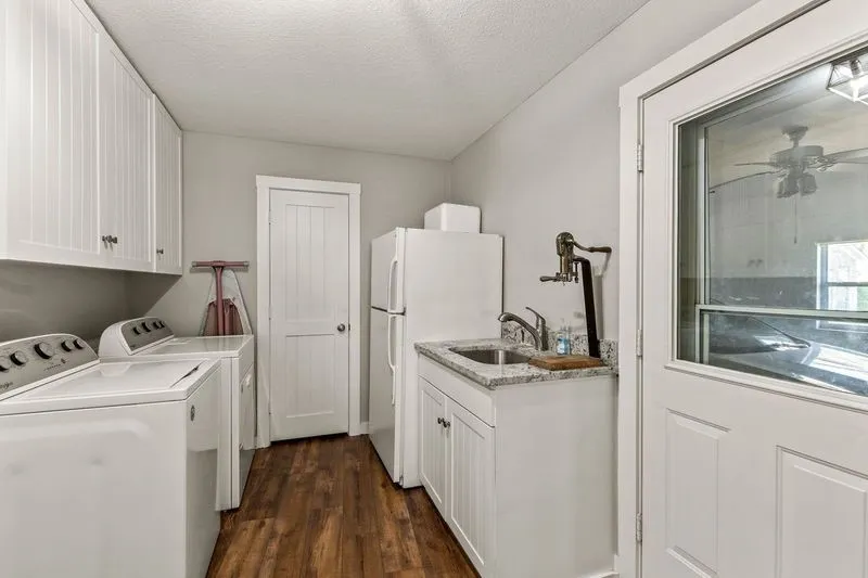 Laundry room with cabinet space, dark wood-type flooring, a ceiling fan, a textured ceiling, and washer and dryer